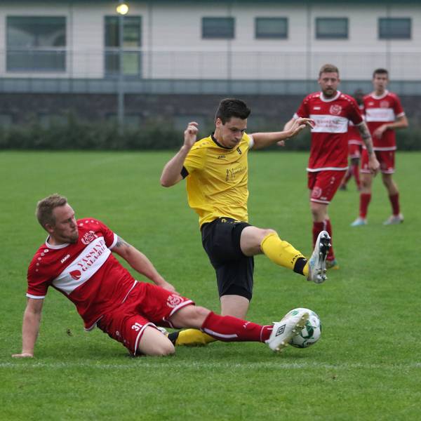 Ein Mechernicher Fußballspieler grätscht nach dem Ball.