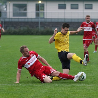 Ein Mechernicher Fußballspieler grätscht nach dem Ball.