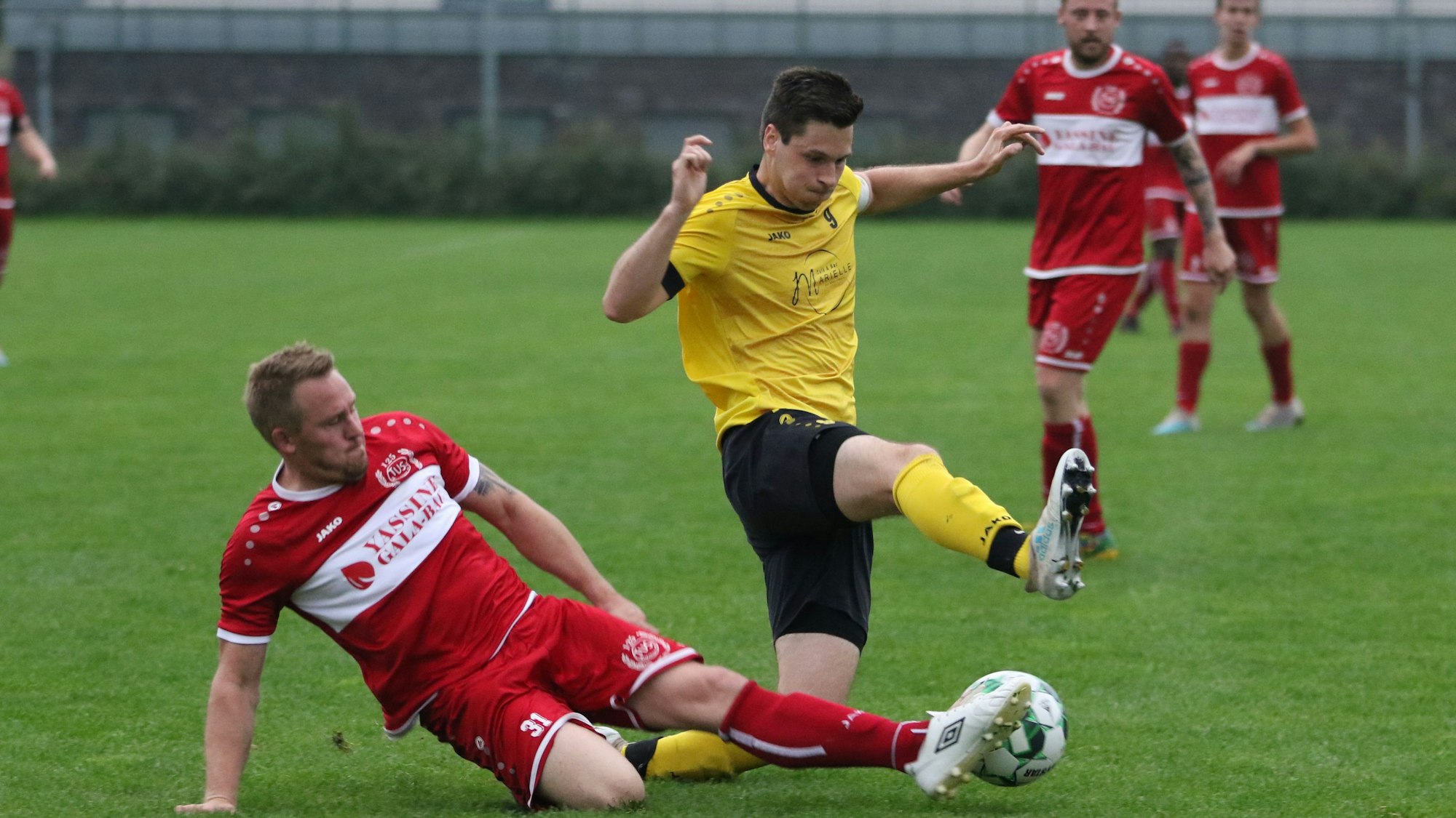 Ein Mechernicher Fußballspieler grätscht nach dem Ball.