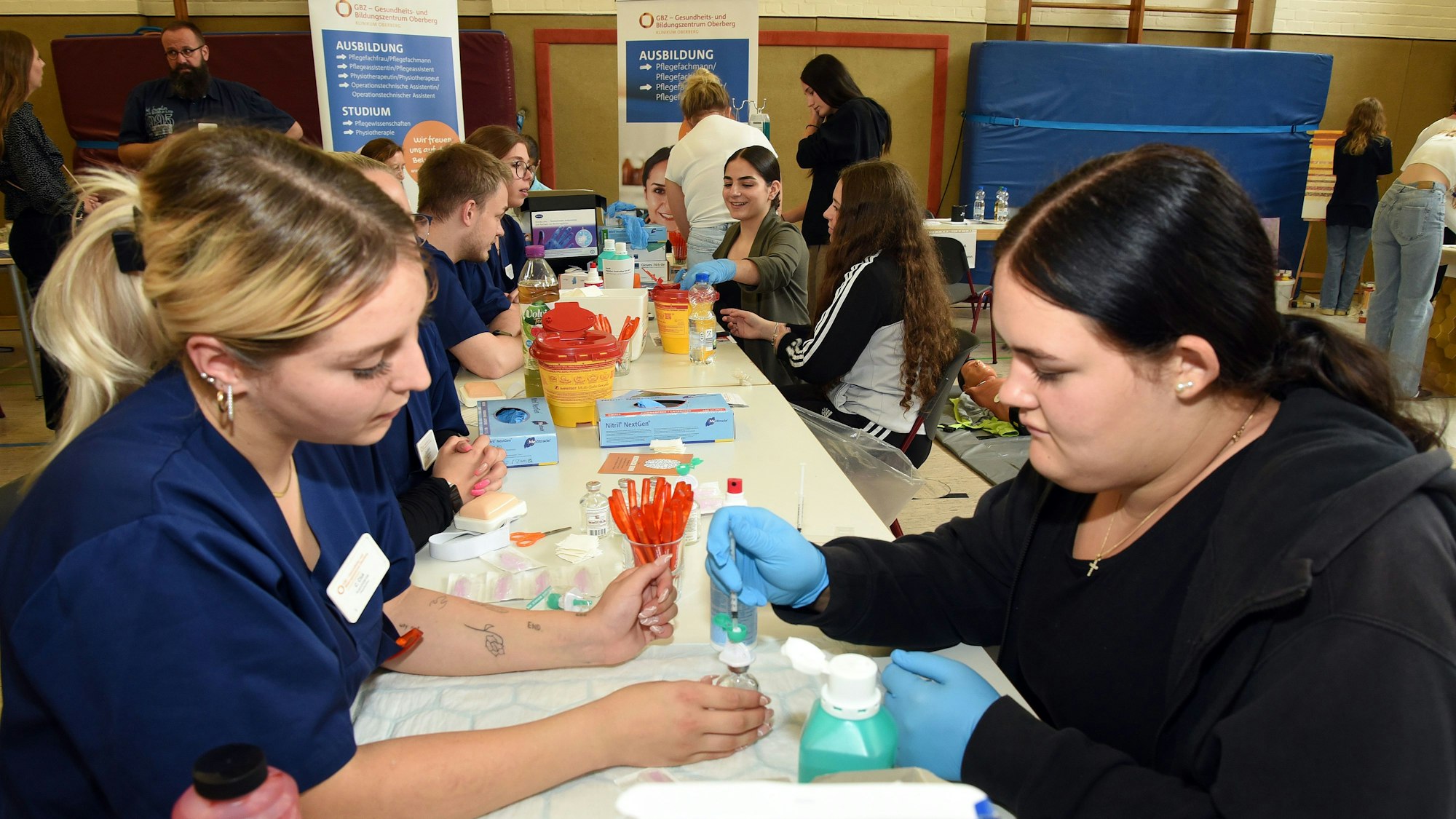 Eine Mitarbeiterin des Gesundheits- und Bildungszentrums Oberberg erklärt einer Schülerin an einem Stand ihre Arbeit.