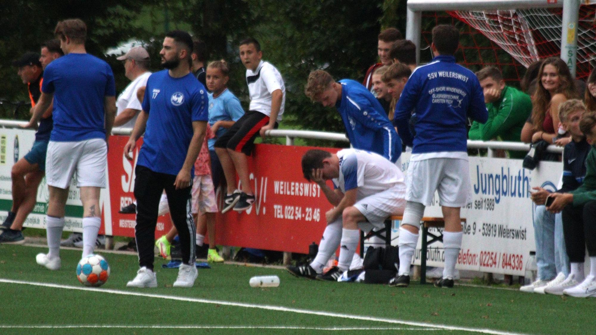 Weilerswists Spieler Felix Bonn vergräbt nach seiner erneuten schweren Verletzung den Kopf in den Händen.
