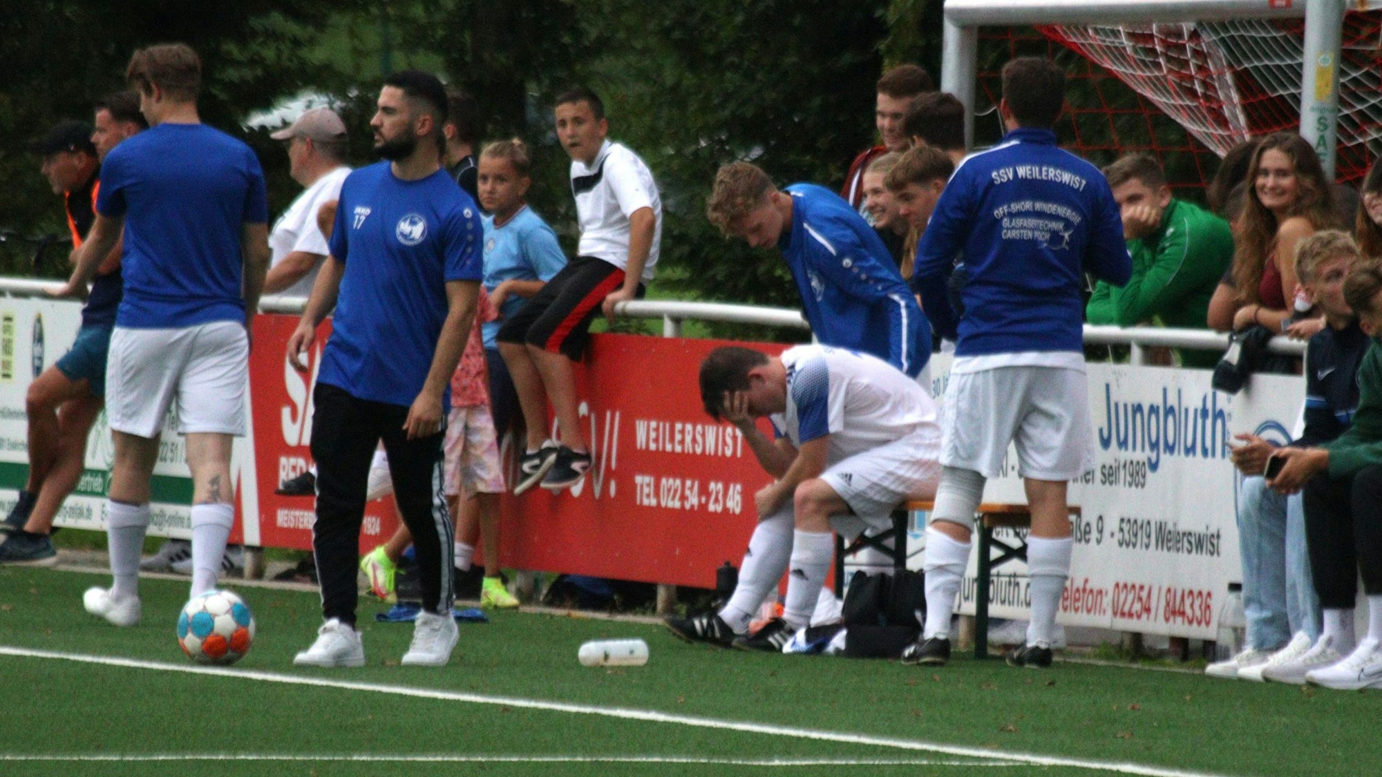 Weilerswists Spieler Felix Bonn vergräbt nach seiner erneuten schweren Verletzung den Kopf in den Händen.