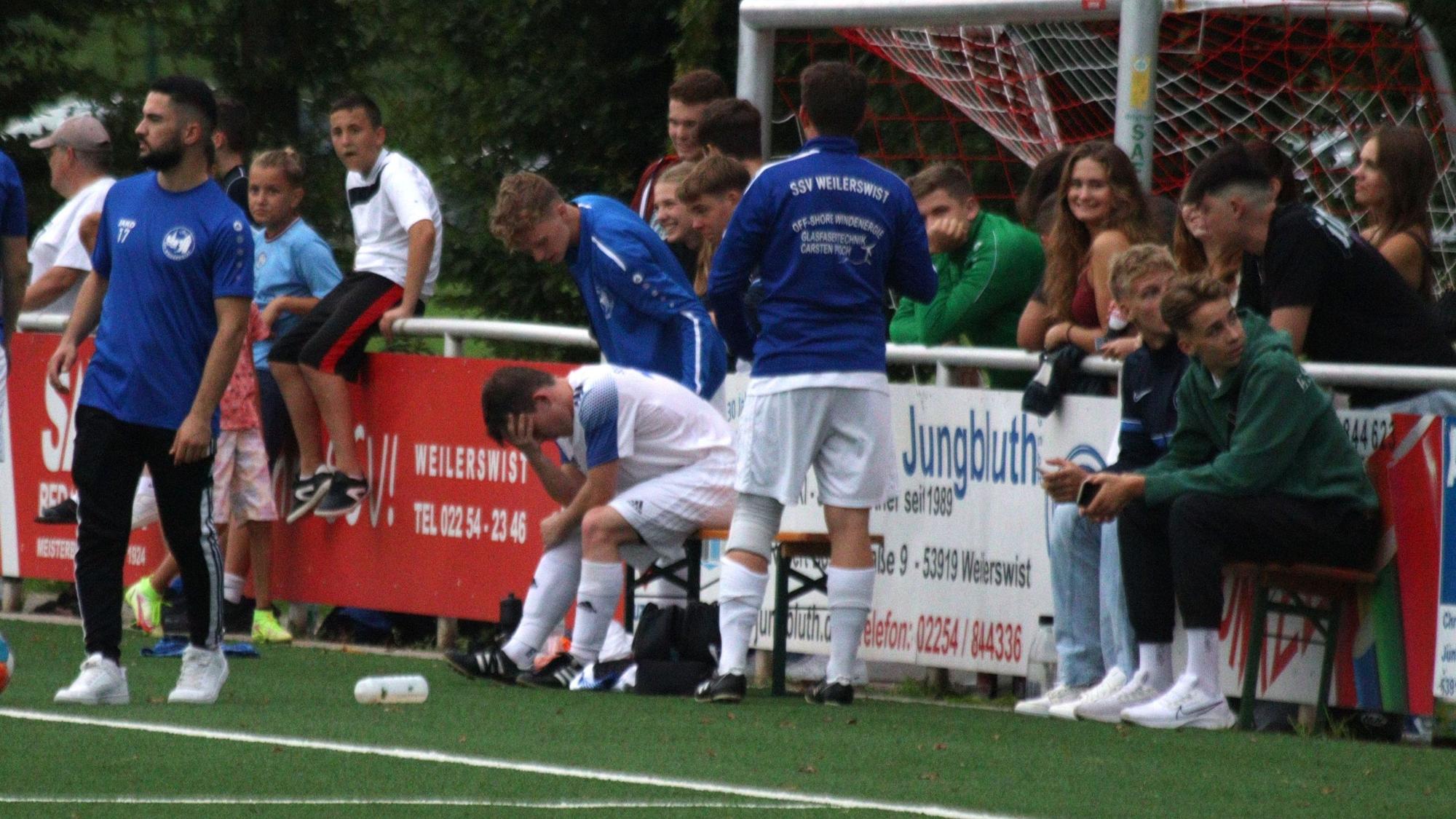 Ein Weilerswister Spieler, der verletzt ausgewechselt wurde, vergräbt den Kopf in seiner Hand.