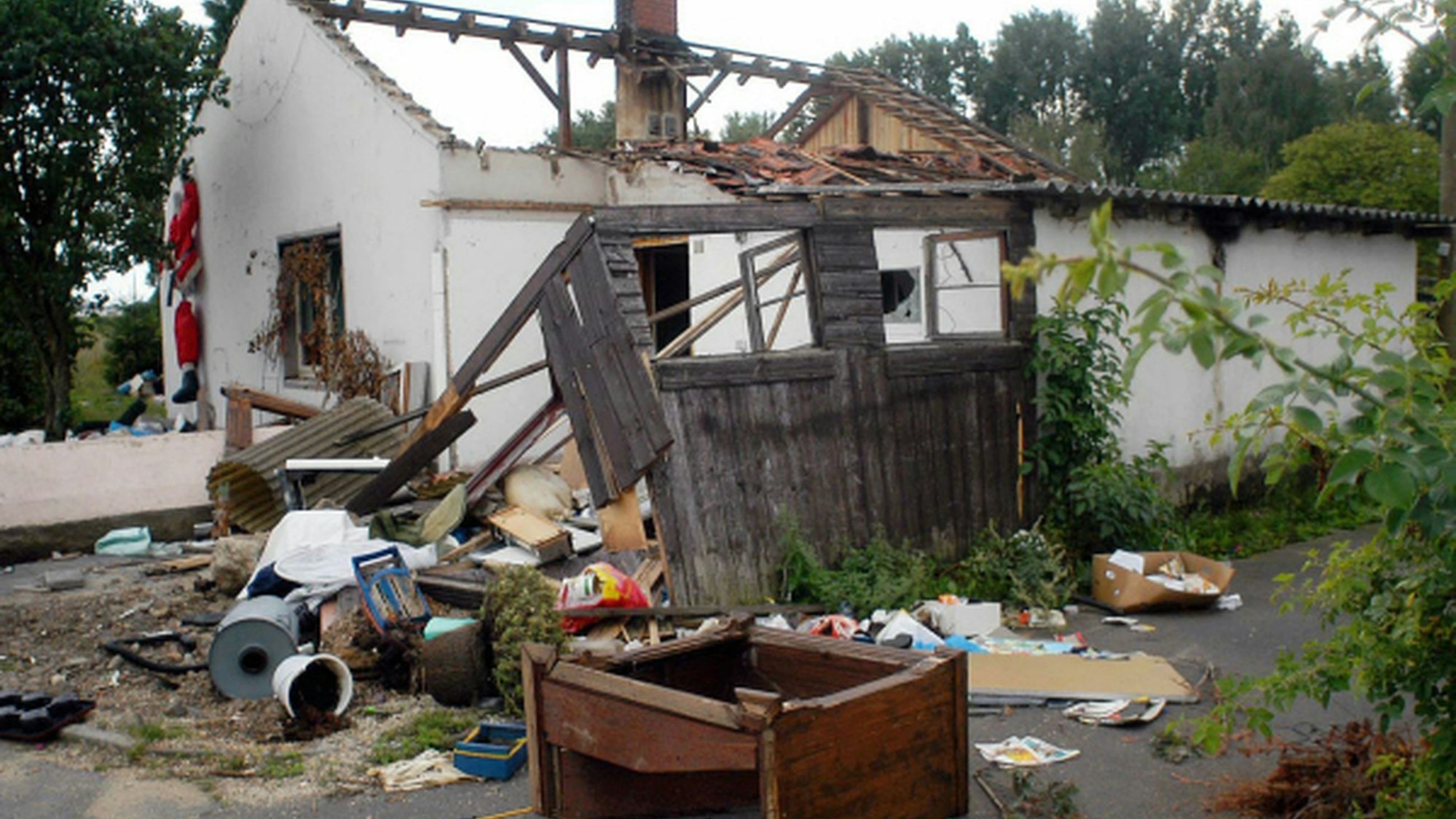 Vor einem baufälligen Haus, das bis 2007 in der Euskirchener Siedlung Rosental stand, liegen Abfall und Gerümpel.