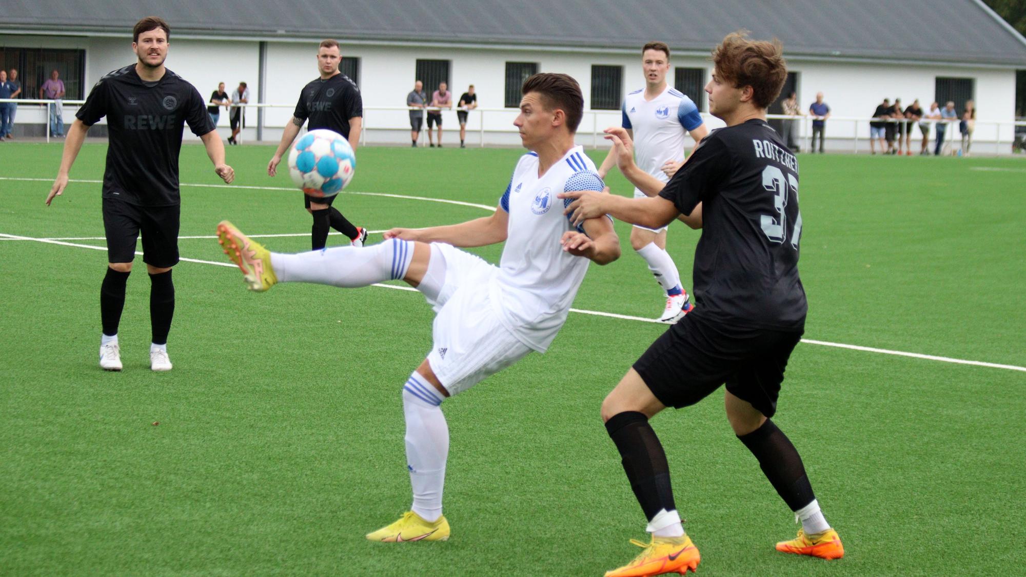 Ein Weilerswister Fußballspieler nimmt den Ball artistisch an und wird von einem Roitzheimger Gegenspieler bedrängt.