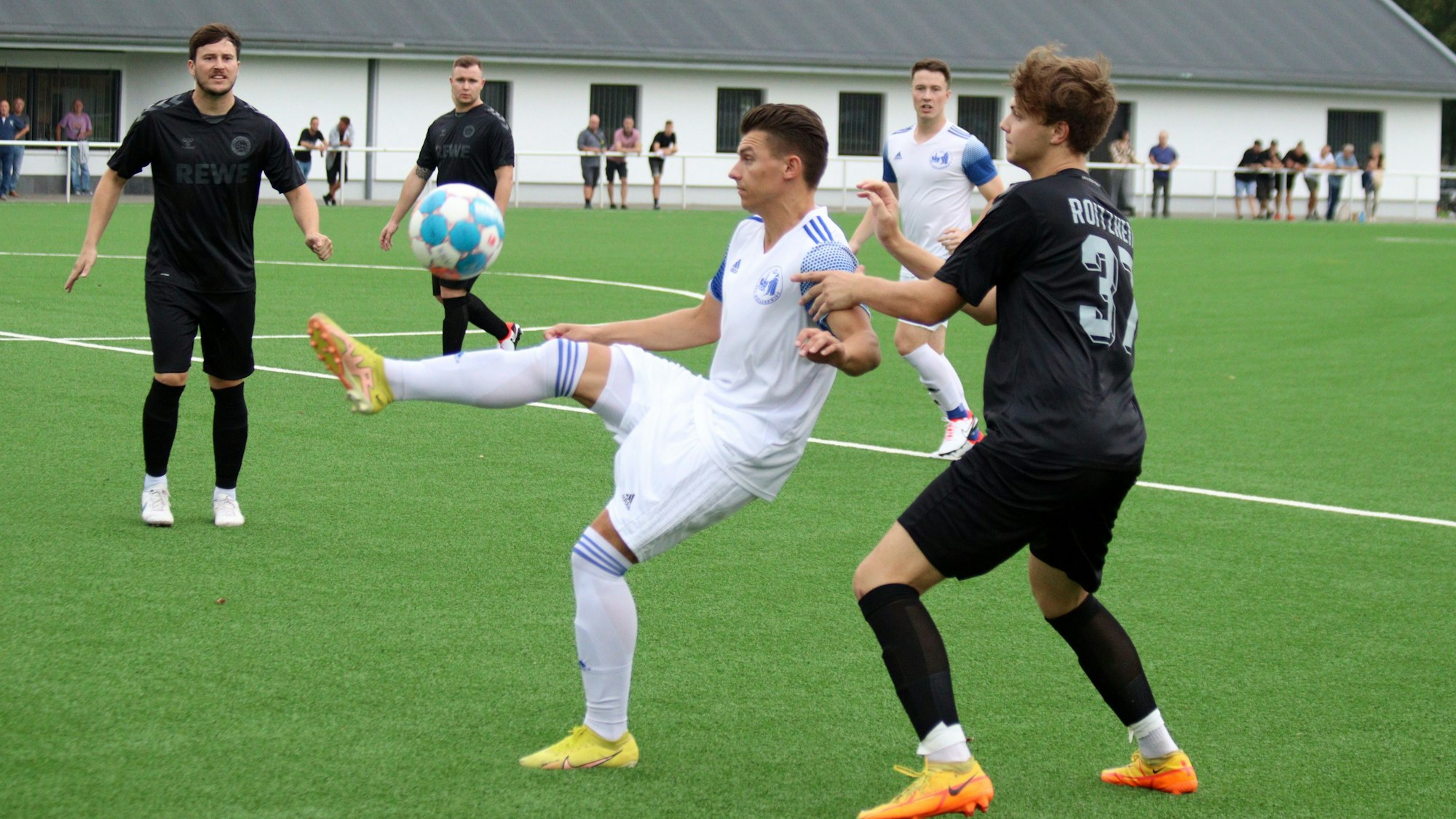 Ein Weilerswister Fußballspieler nimmt den Ball artistisch an und wird von einem Roitzheimger Gegenspieler bedrängt.