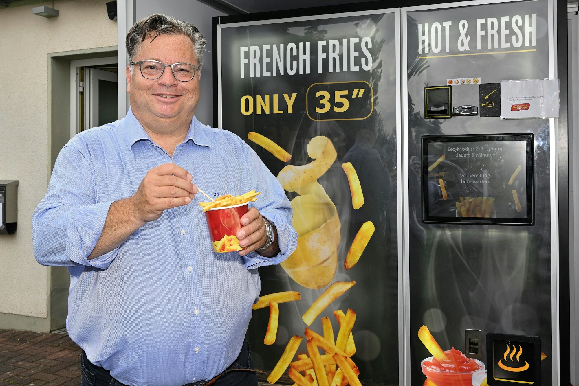 Das Foto zeigt Stefan Ohligschläger, der an seinem Frittenautomaten an der Reuterstraße 110 steht.