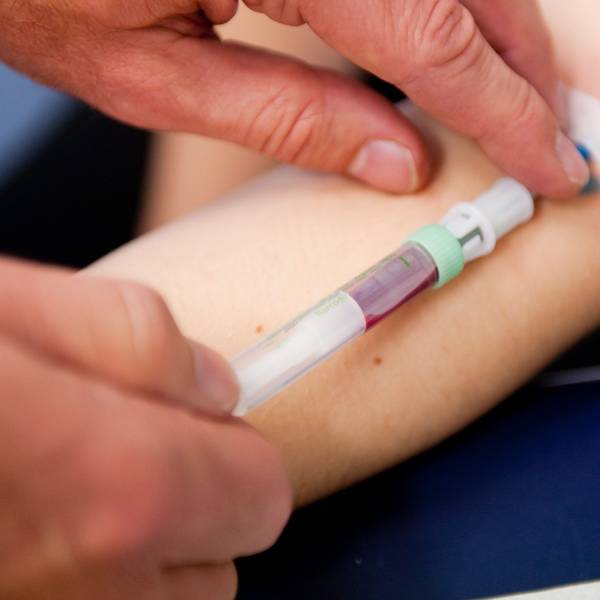 Eine Frau bekommt Blut abgenommen, Nahaufnahme
