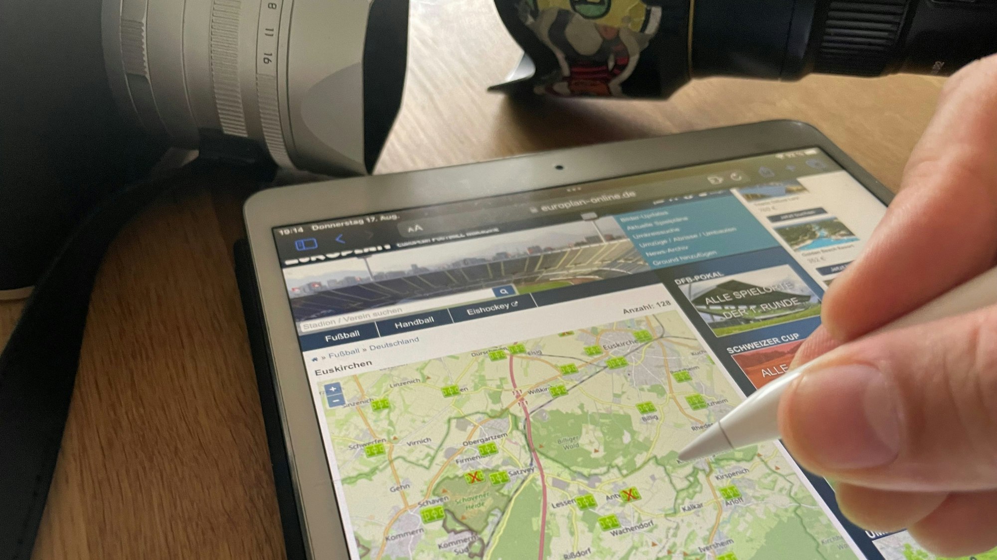 Zu sehen sind eine Karte auf einem Tablet, im Hintergrund liegen zwei Kameras.