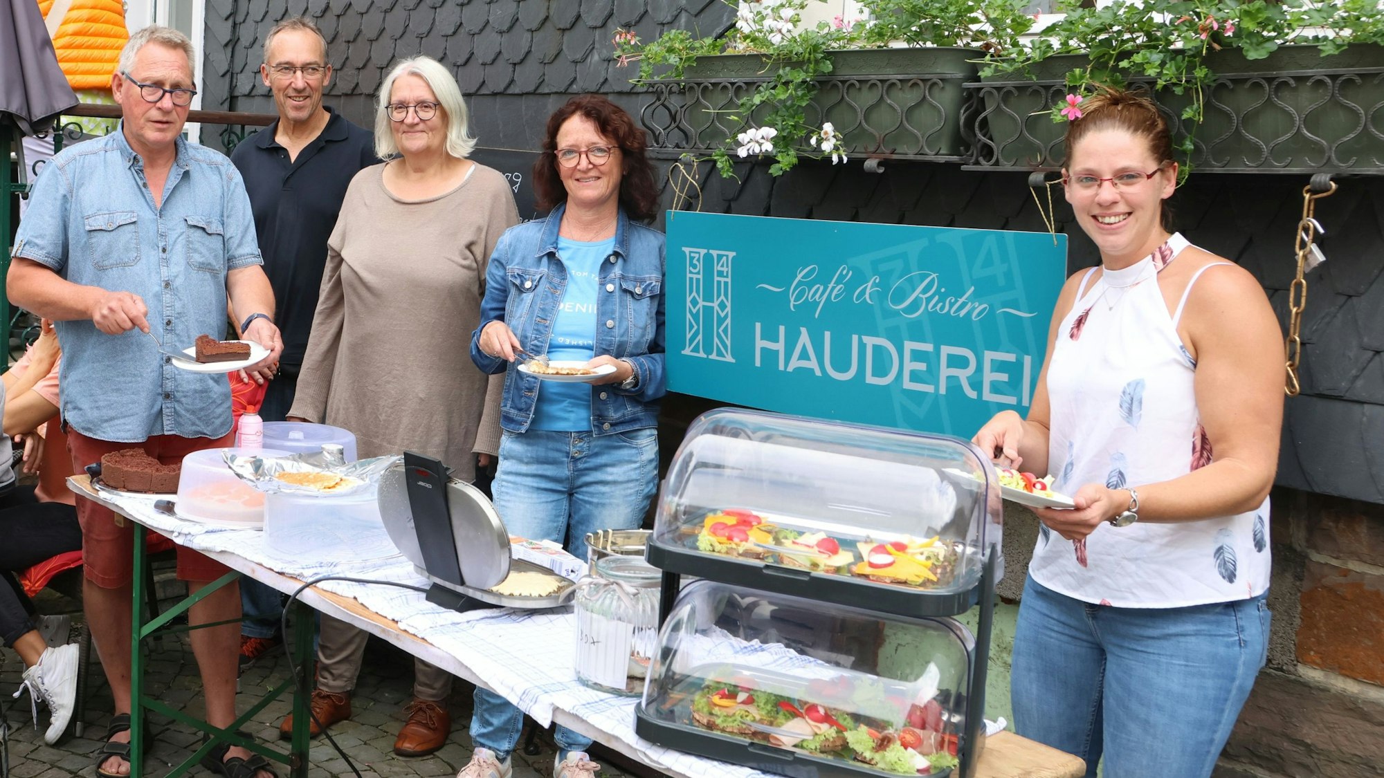 Das Team der „Hauderei“ um Vorstandschef Bernd-Uwe Mach (links) steht in Waldbröl vor dem Haus, in dem das neue Genossenschafts-Café eingezogen ist. An Markttagen servieren die Mitglieder dort bereits Waffeln, Schnittchen und Kuchen. Mach zur Seite stehen (v.l.) Martin Klein, Anne Pampus, Sabine Schlechtriem und Jasmin Neubert.
