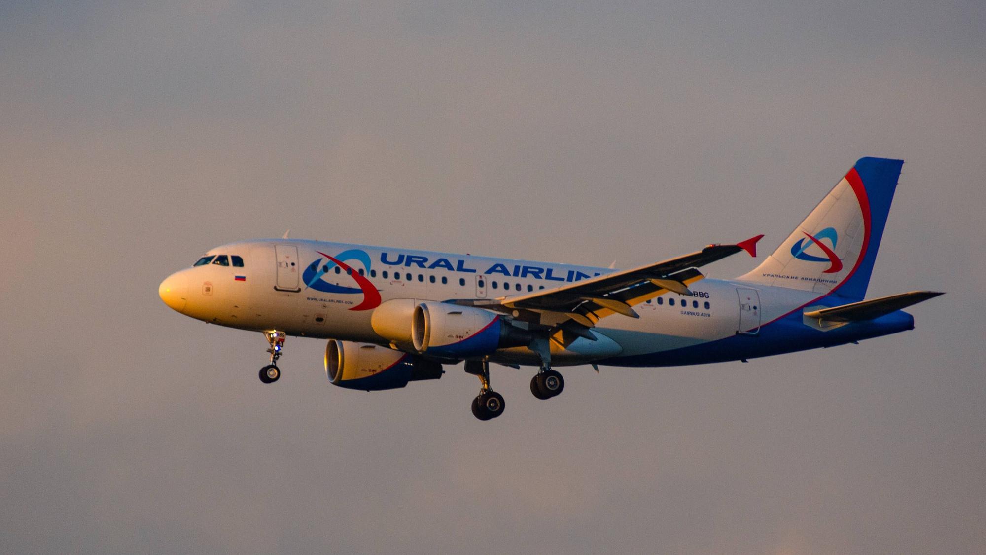 Ein Airbus A319 der russischen Fluggesellschaft Ural Airlines fliegt am Himmel. Von vorne scheint die Sonne auf das Flugzeug. (Symbolbild)