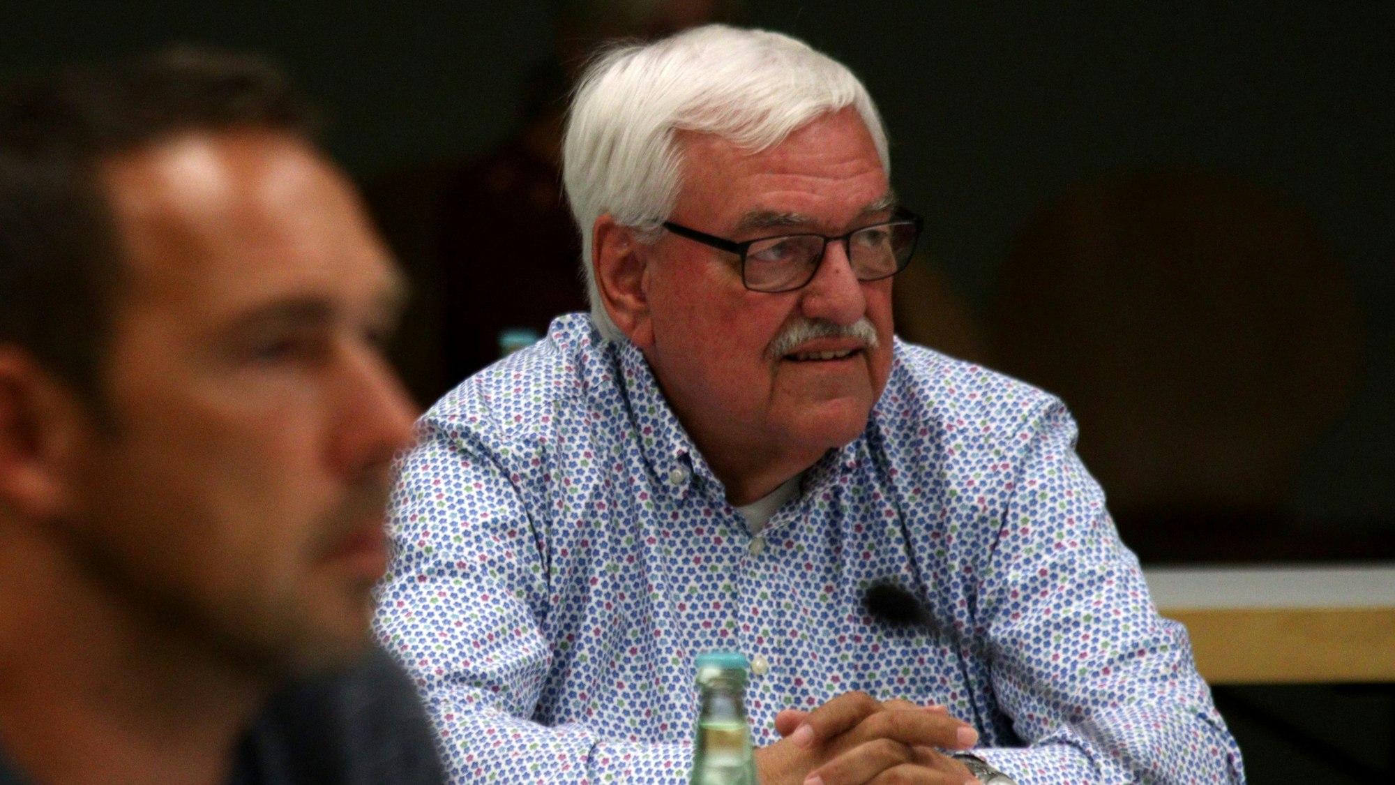 Hans Peter Nußbaum sitzt während einer Ratssitzung hinter einem Mikrofon.