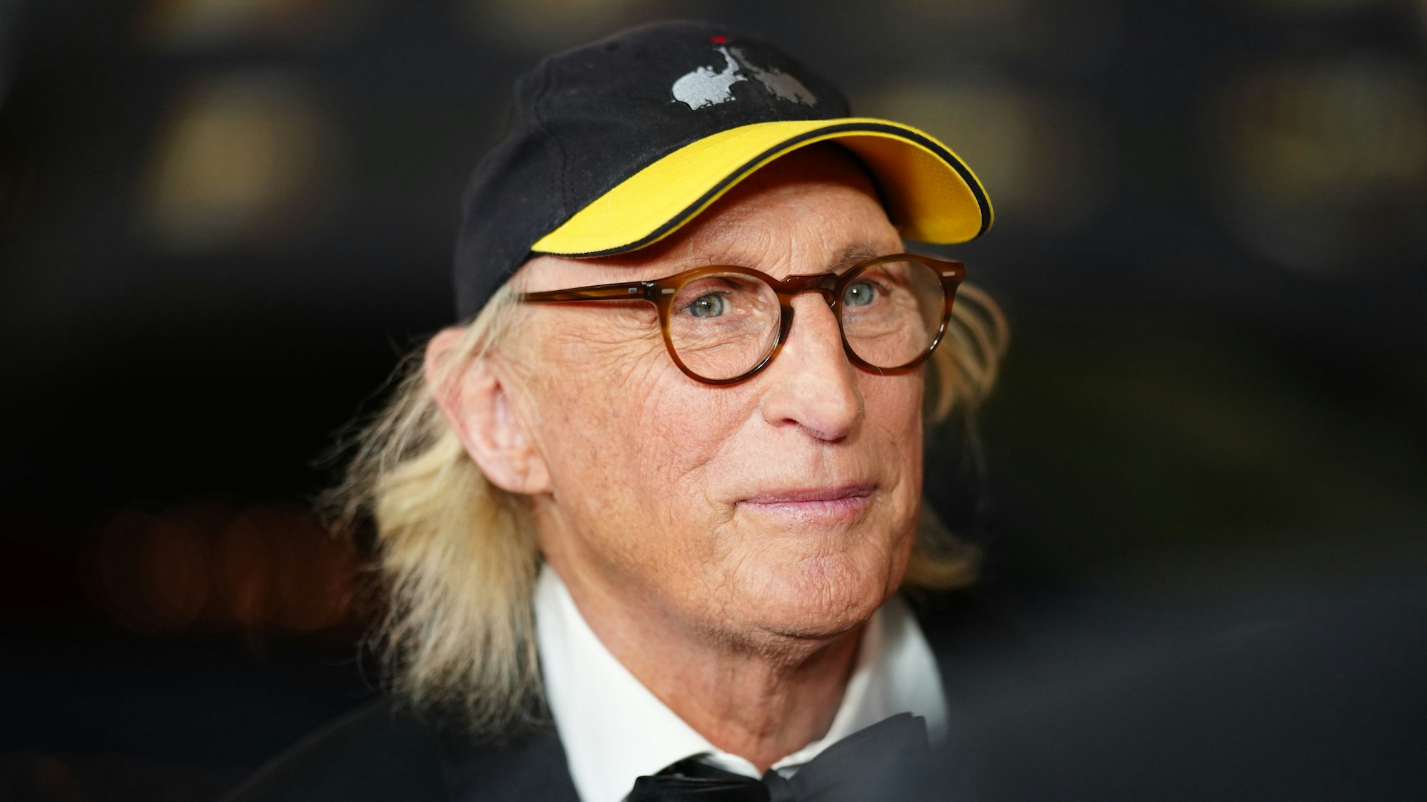 Der Komiker Otto Waalkes auf dem Roten Teppich in einem Anzug. Er trägt dabei seine berühmte „Ottifanten“-Kappe.