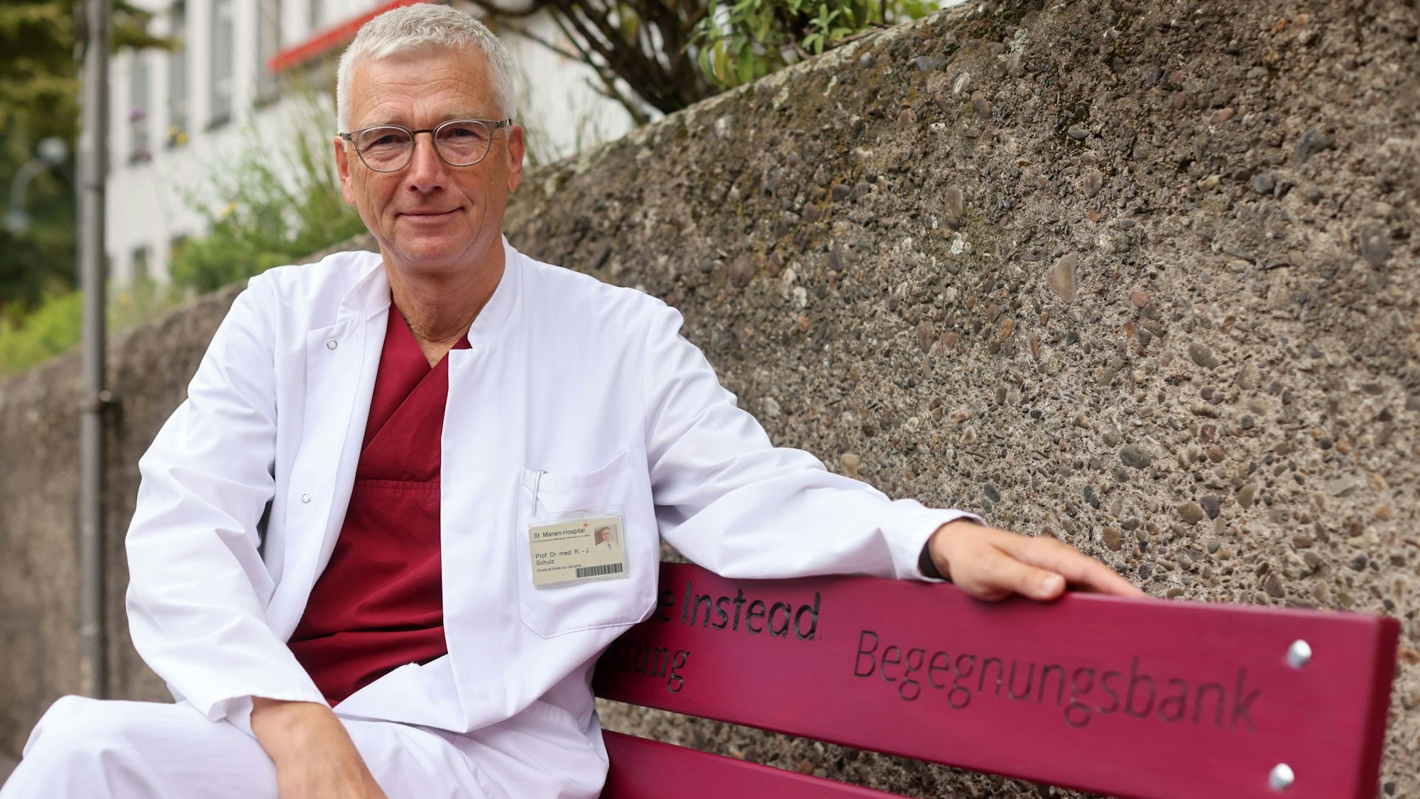 Prof. Dr. Ralf-Joachim Schulz sitzt auf der pinken Bank.