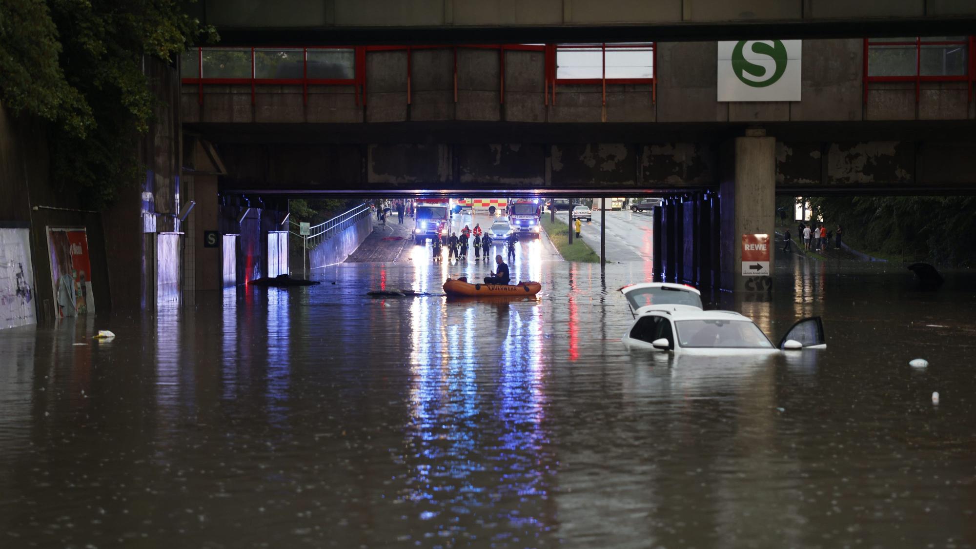 Einsatzkräfte der Feuerwehr können nur noch mit einem Schlauchboot zu den Autos in einer überschwemmten Unterführung gelangen. Starkregen hat in Nürnberg am Donnerstagabend zu zahlreichen Einsätzen von Polizei und Feuerwehr geführt.