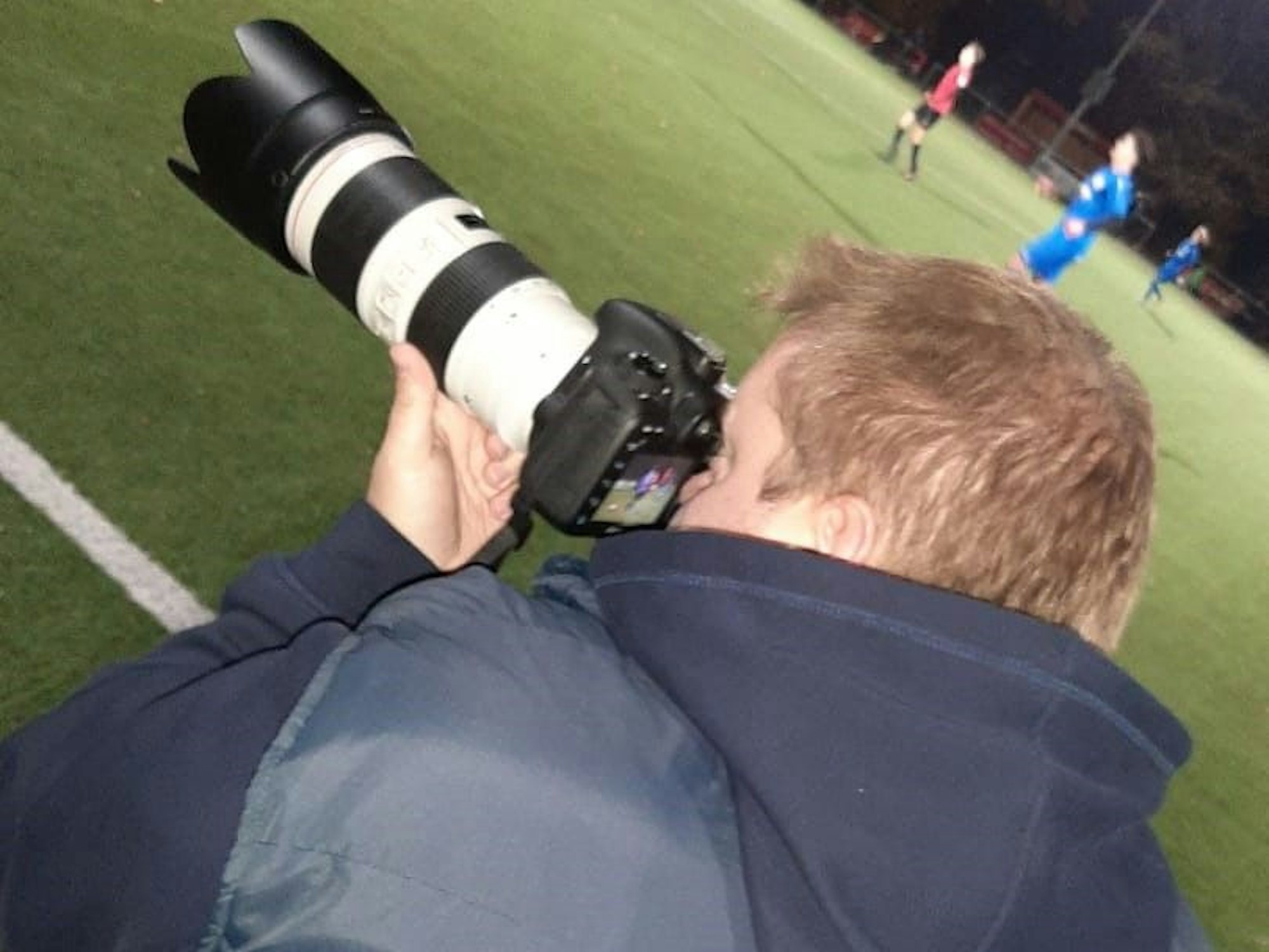Sportreporter Rocco Bartsch fotografiert ein Fußballspiel.