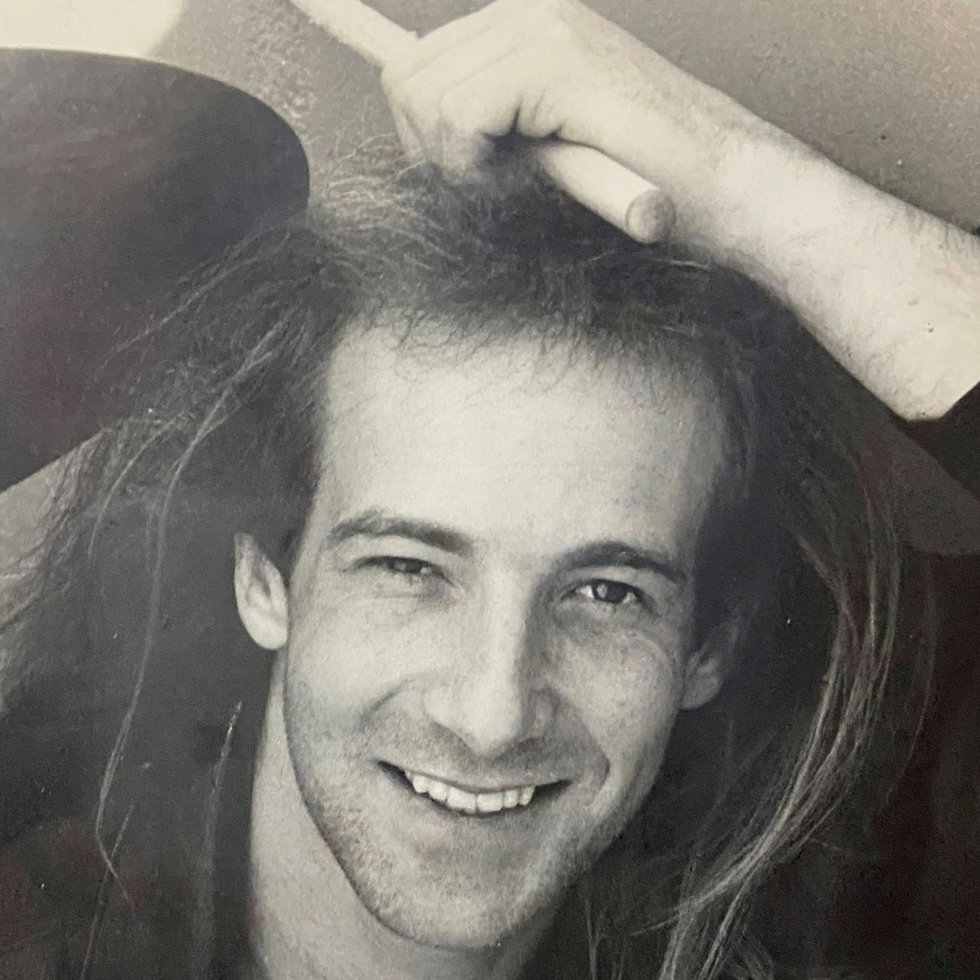 Ein junger Mann lacht in die Kamera.