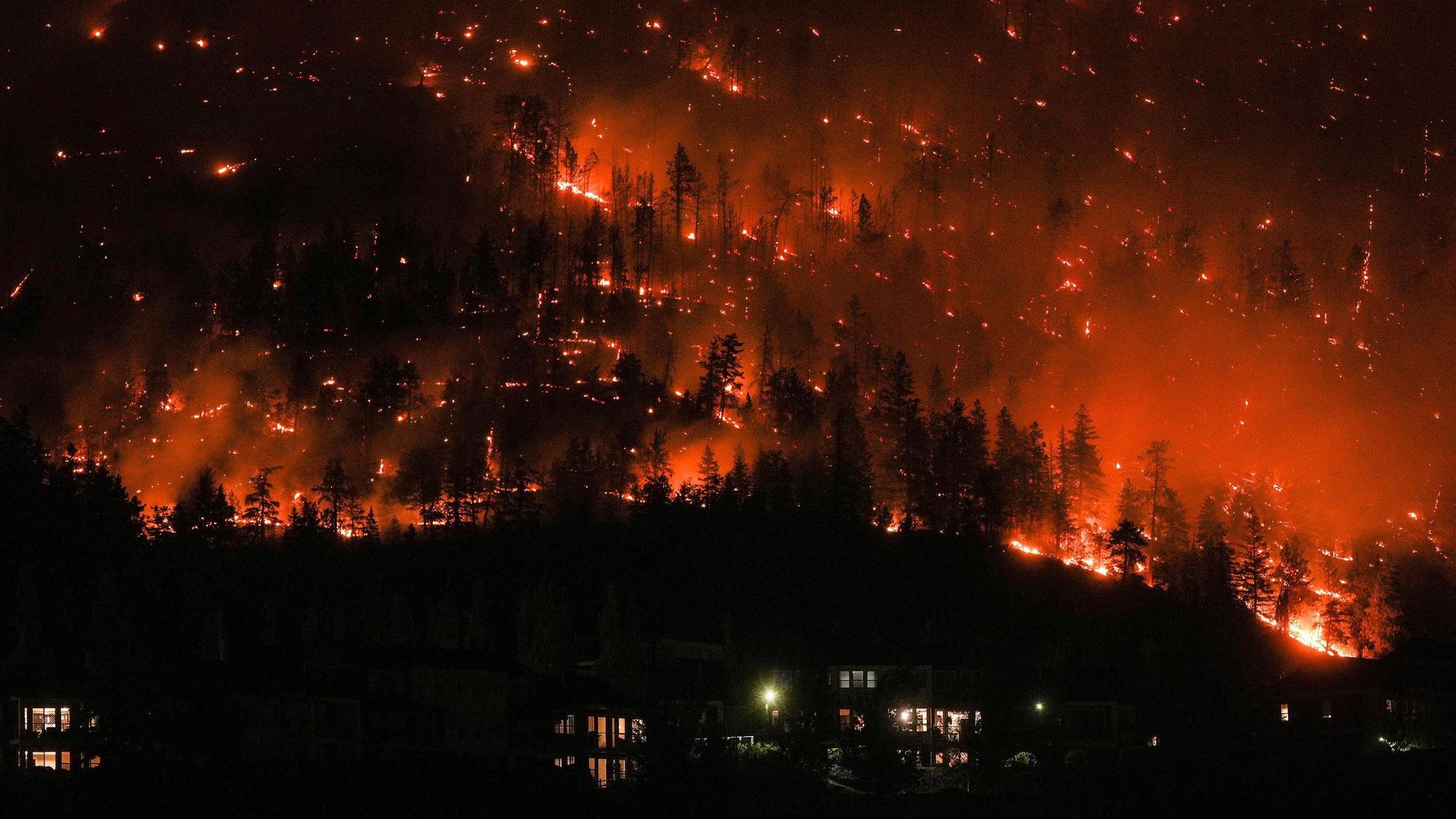 dpatopbilder - 18.08.2023, Kanada, West Kelowna: Ein Waldbrand am McDougall Creek an einem Berghang oberhalb von Häusern.
