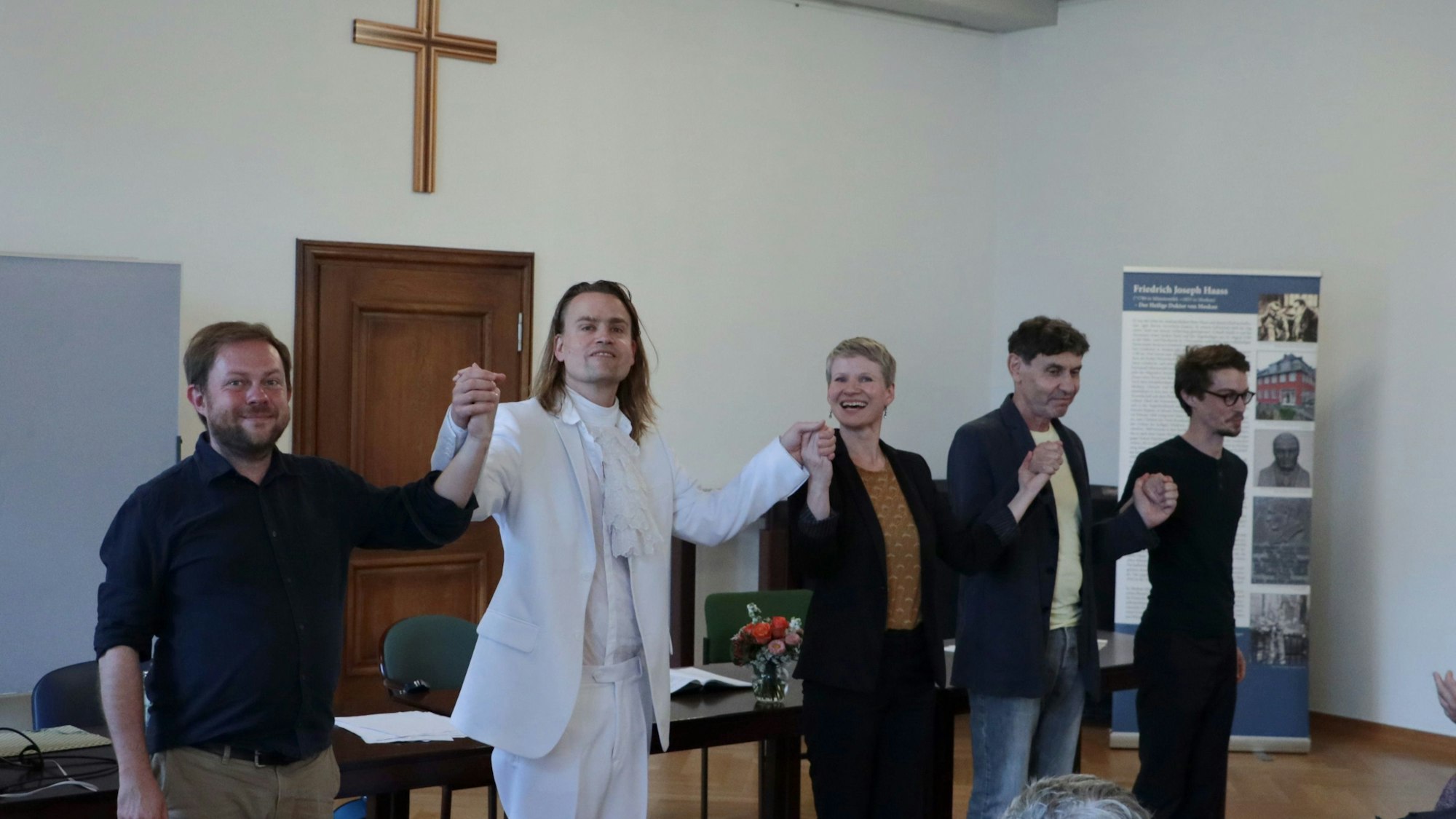 Das Bild zeigt René Michaelsen, Laurenz Leky, Juliane Pempelfort, Mark Zak und Alexander Olbrich. Sie halten sich an den Händen.