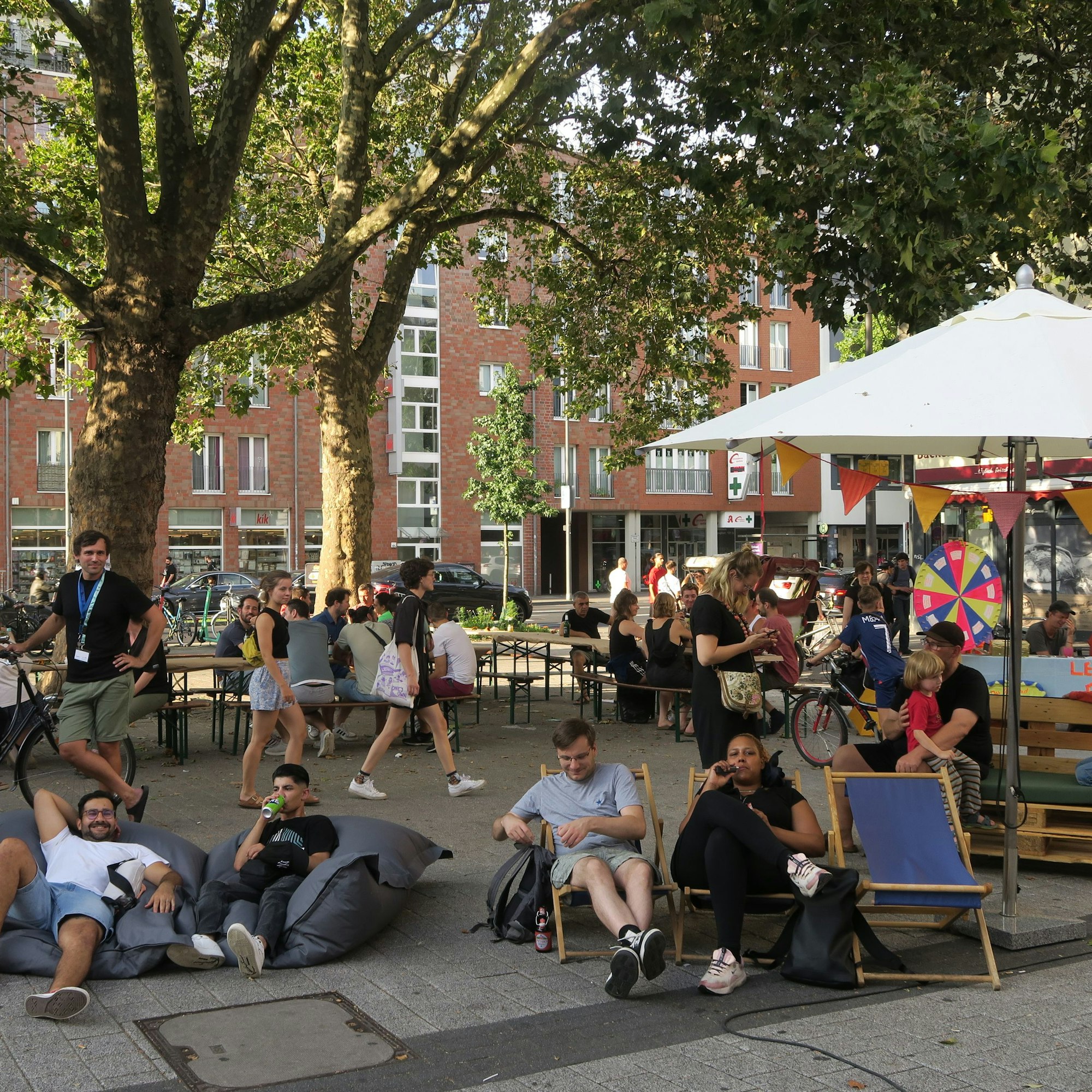 Menschen liegen in Liegestühlen auf dem Vorplatz.