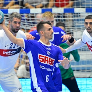 VfL-Spieler Milos Vujovic ist mit dem Ball in Wurfposition vor der Abwehr von Paris Saint-Germain zu sehen.