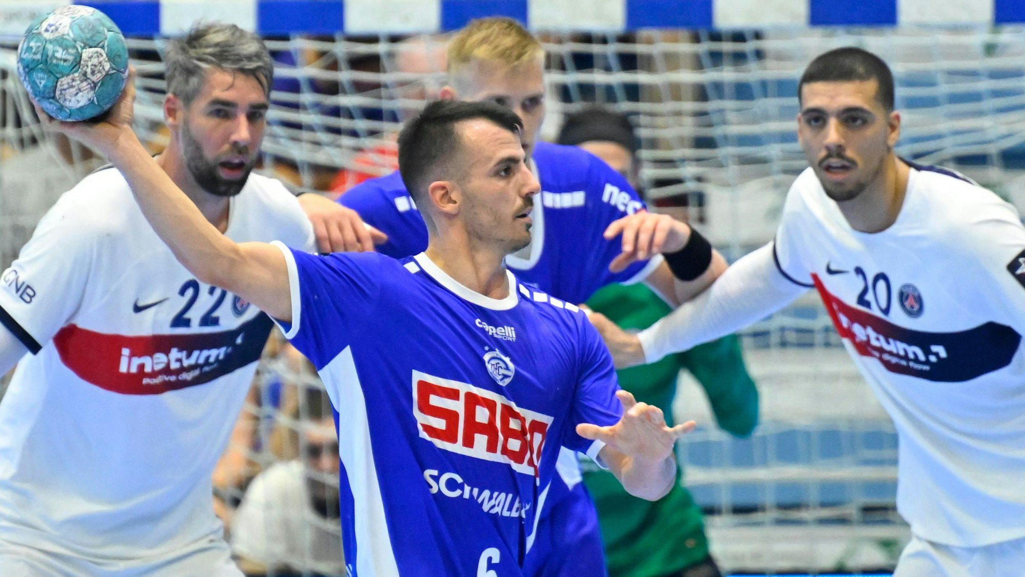 VfL-Spieler Milos Vujovic ist mit dem Ball in Wurfposition vor der Abwehr von Paris Saint-Germain zu sehen.