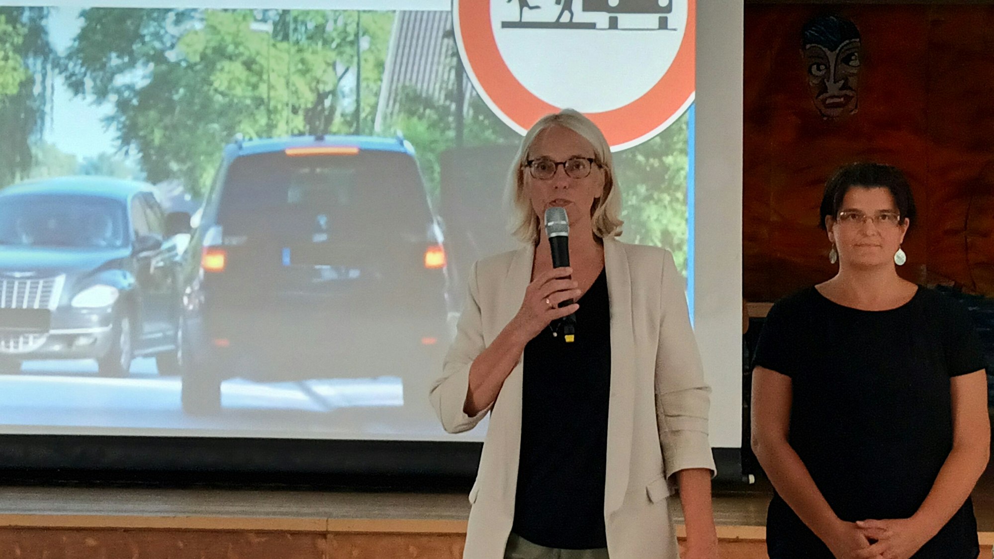 Claudia Wieja (l.) und Schulwegsexpertin Dr. Tabea Kesting sprechen vor einer in der Anliegerversammlung.
