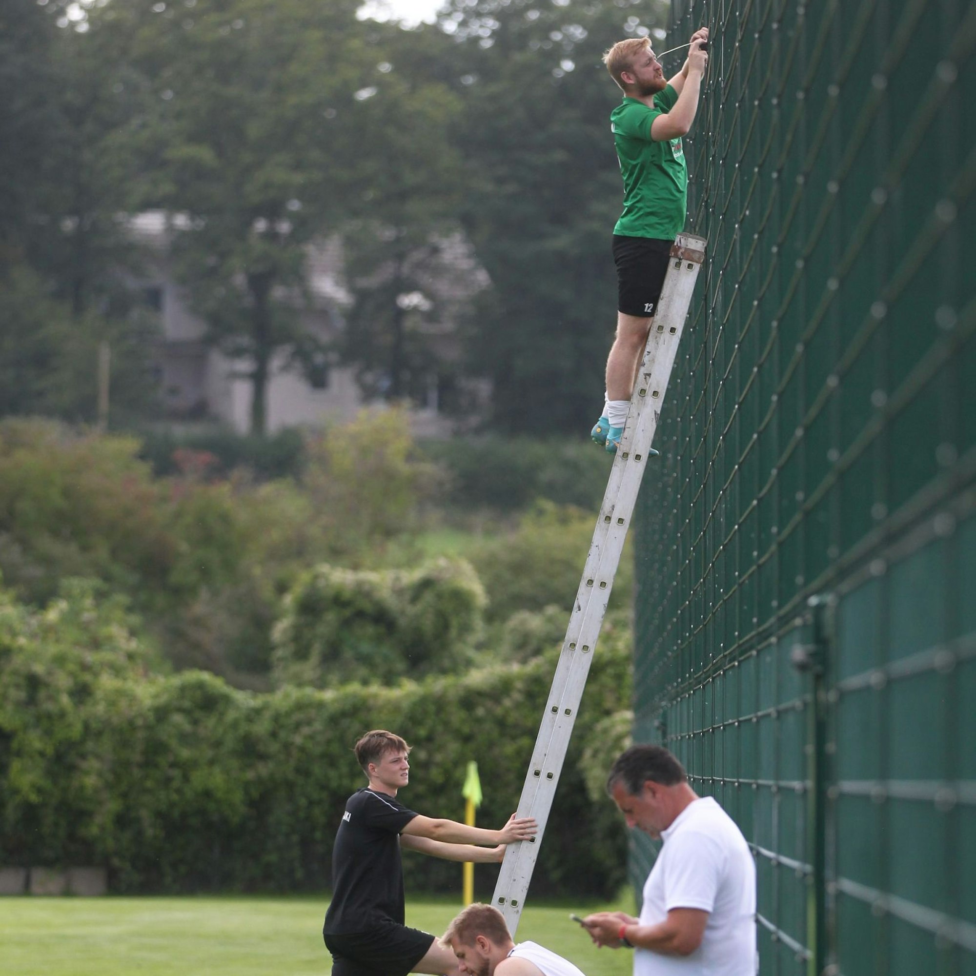 Ein Vertreter von Flamersheim/Kirchheim steht auf einer Leiter, die an den Fangzaun lehnt.