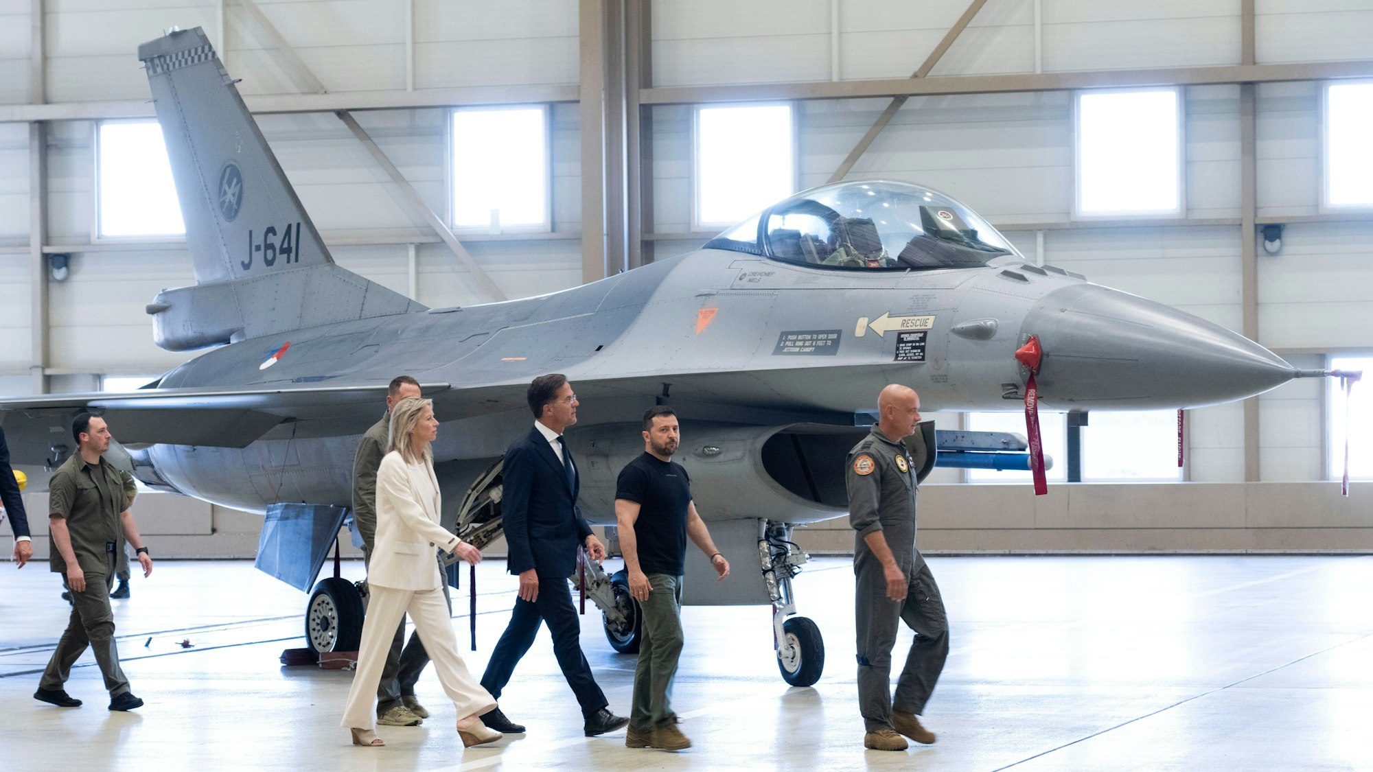 Wolodymyr Selenskyj und Mark Rutte laufen an einem F-16 Kampfjet vorbei.