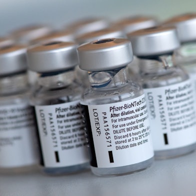 Leere Ampullen des Impfstoffs von Biontech/Pfizer gegen das Corona-Virus SARS-CoV-2 stehen in einem Impfzentrum nach der Vorbereitung der Spritzen auf einem Tisch.