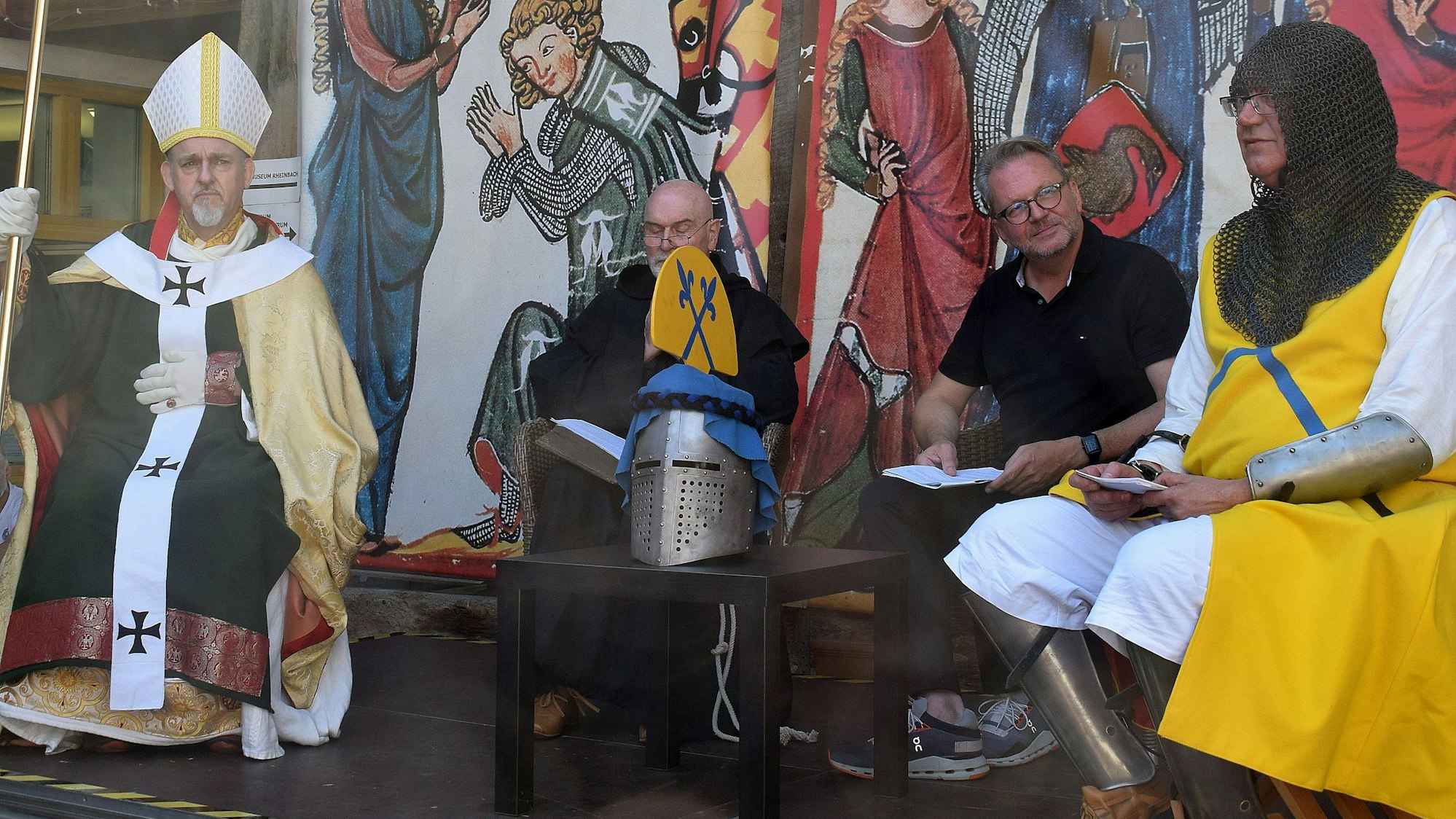 Erzbischof Wigbold von Köln (Robert Heller), der Abt von Prüm (Fred Paral) und Theoderich, Ritter von Rheinbach (Dietmar Perz) (von links) stellten sich Moderator Heiko Hecking (2. von rechts) im Himmeroder Hof einer historischen Podiumsdiskussion zur Stadtgründung Rheinbachs. Foto: Frank Engel-Strebel