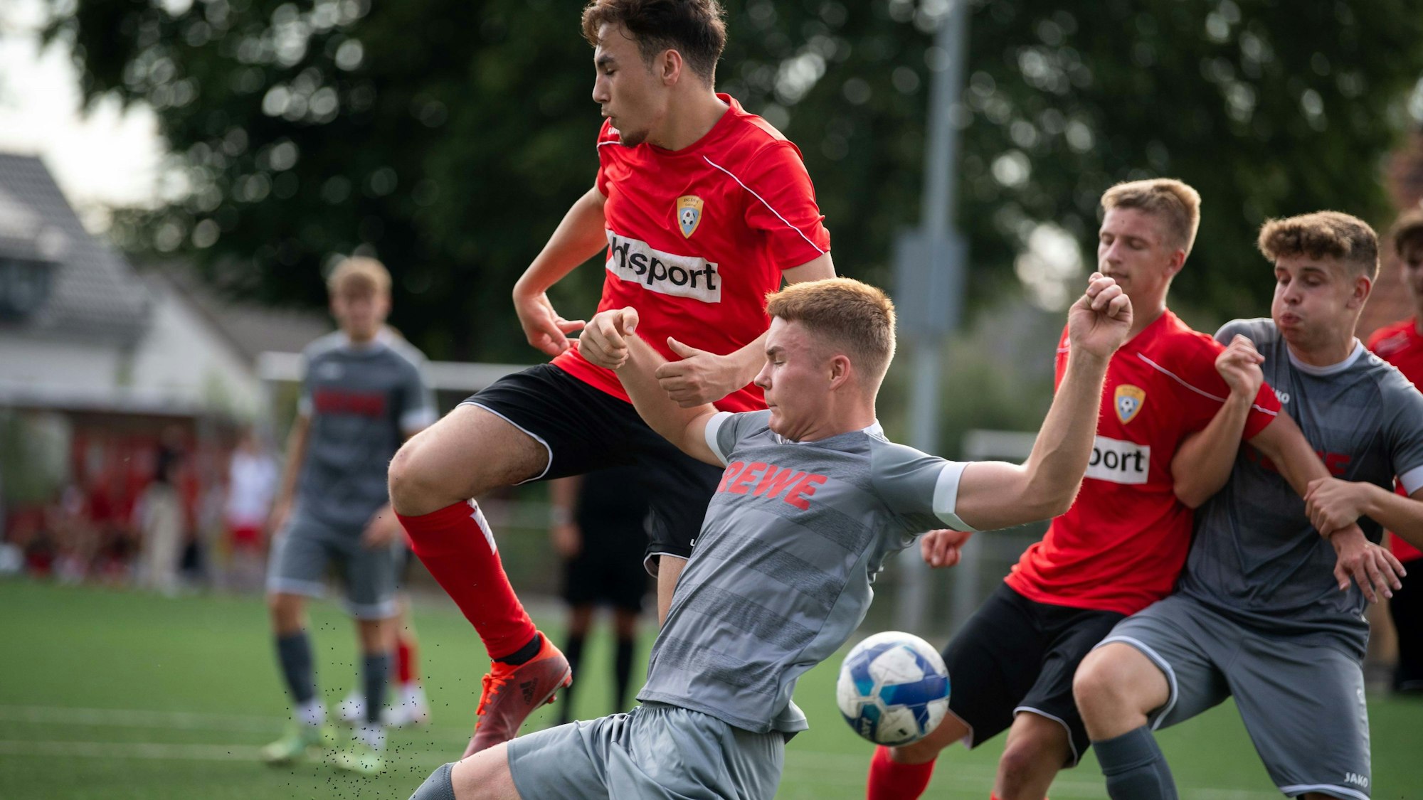 Das Bild zeigt mehrere Fußballer nach einem Eckball, wie sie versuchen, den Balll zu erreichen.