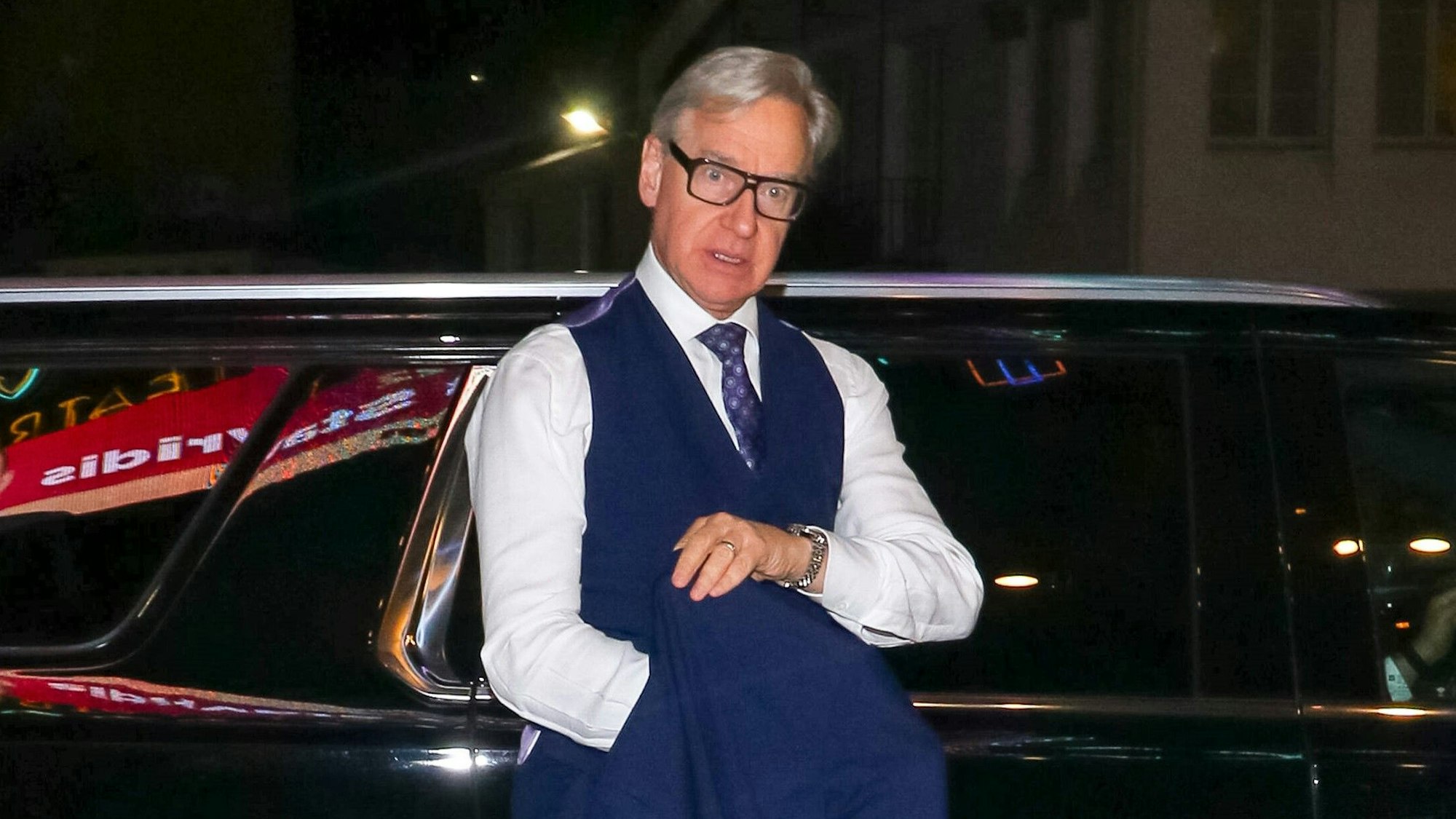 Regisseur Paul Feig lehnt an einem Auto und schaut abwesend schräg nach unten.