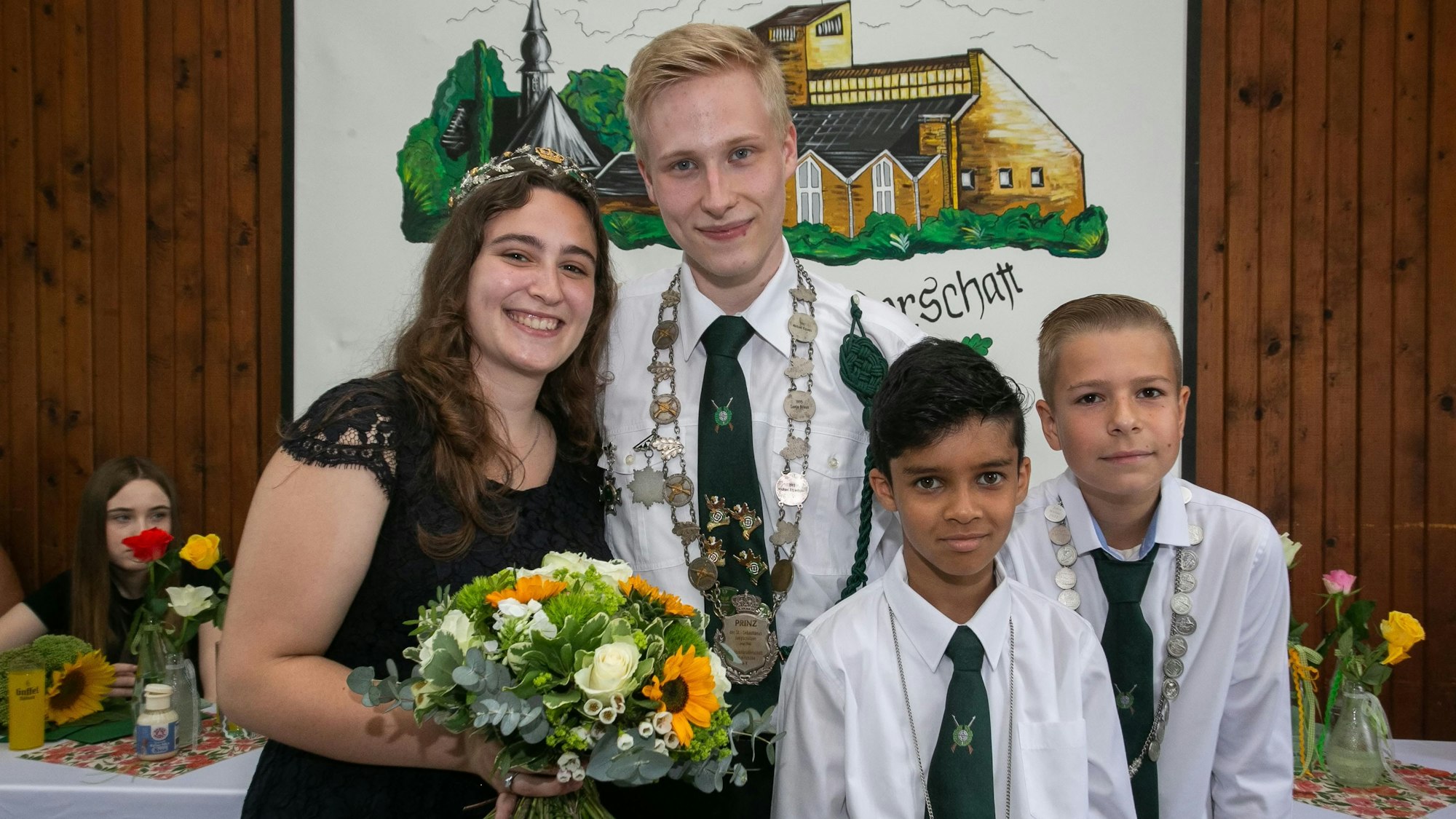 Die neuen Majestäten des Schützenvereins Schmitzhöhe: Zwei Jugendliche und zwei Jungs stehen zum Gruppenfoto zusammen.