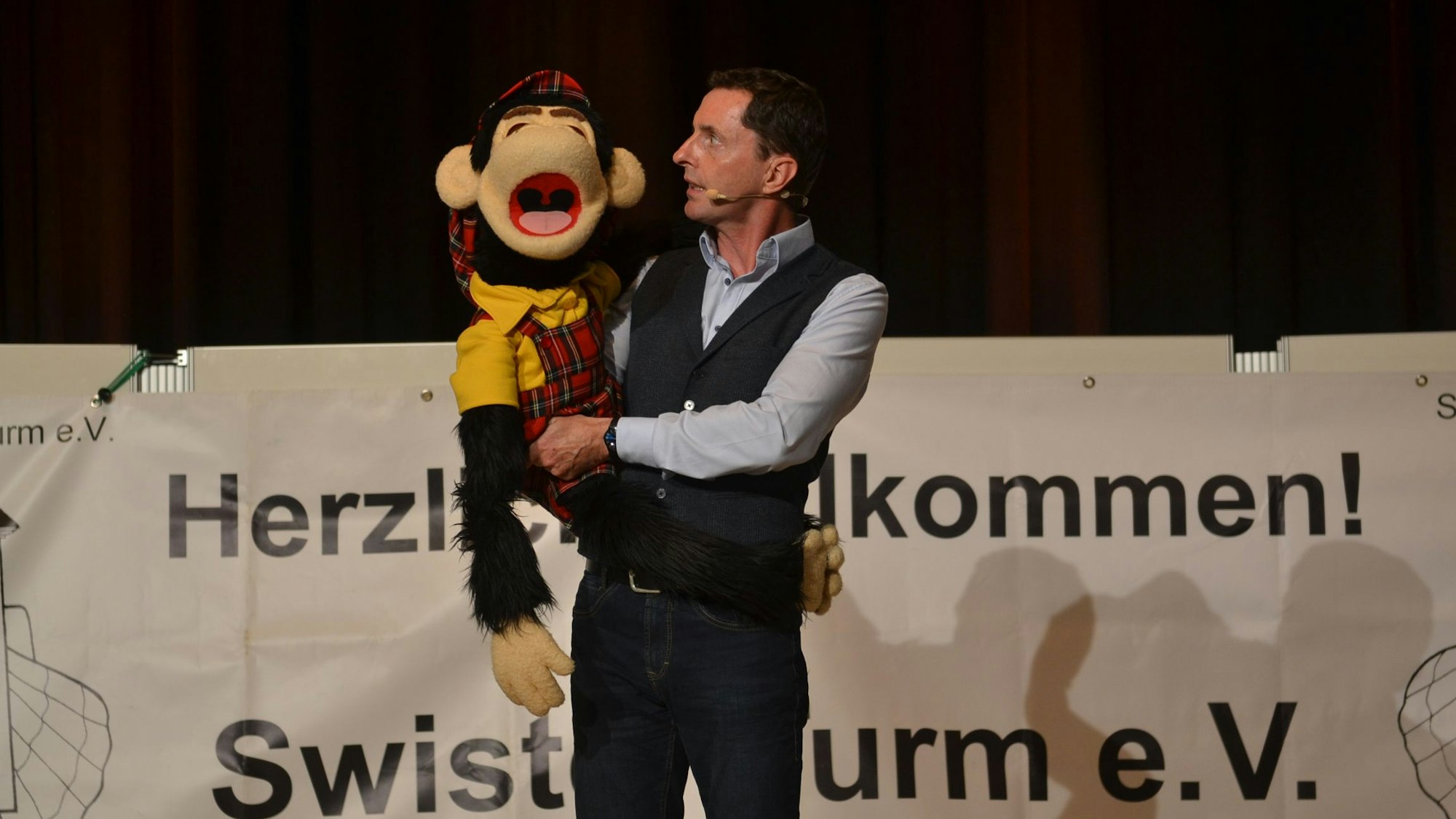 Der Bauchredner Klaus Rupprecht hält bei einem Auftritt in Weilerswist seinen „Partner“, einen Plüsch-Affen, im Arm.
