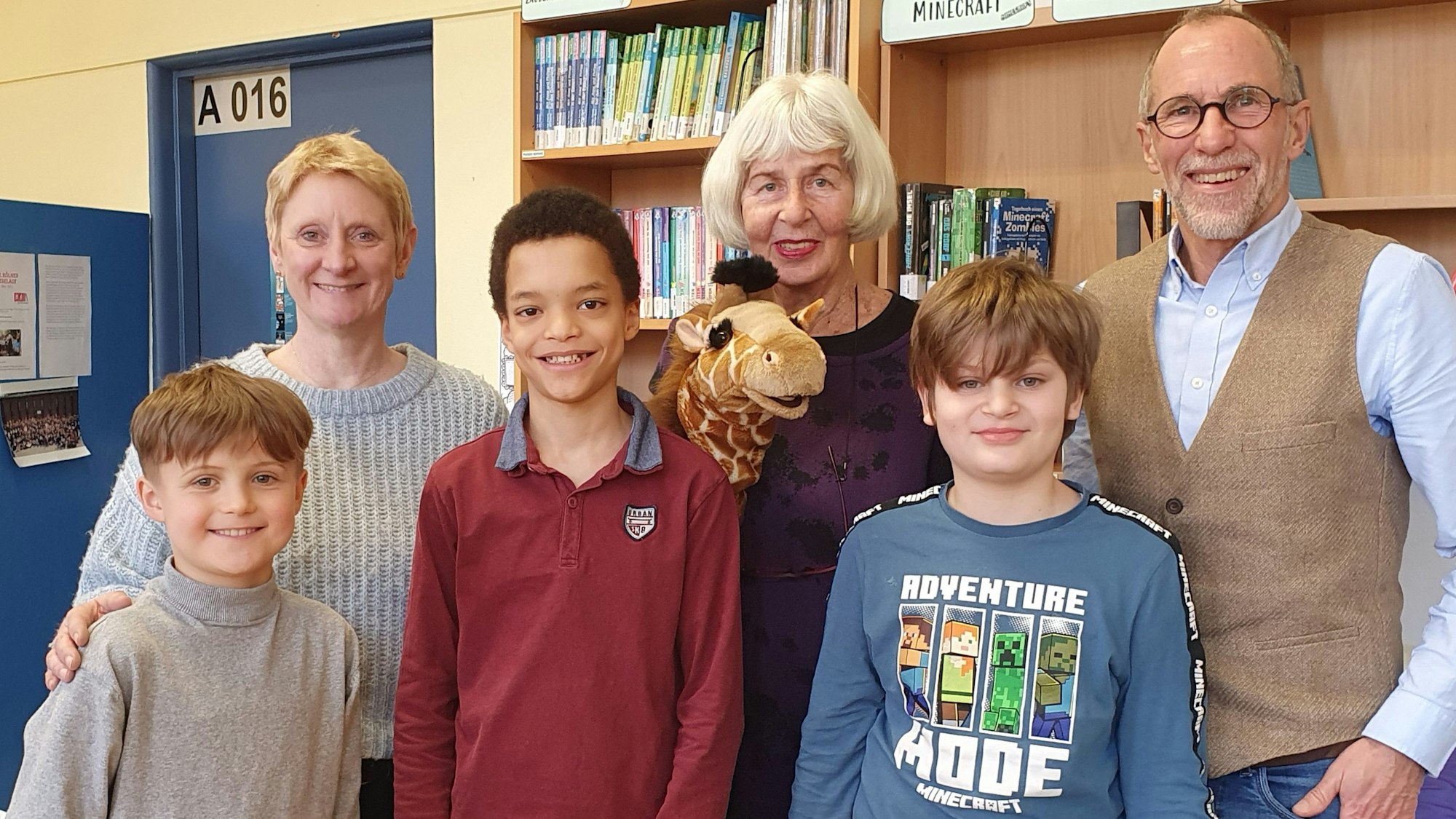 Drei Erwachsene und drei Jungs stehen nebeneinander.