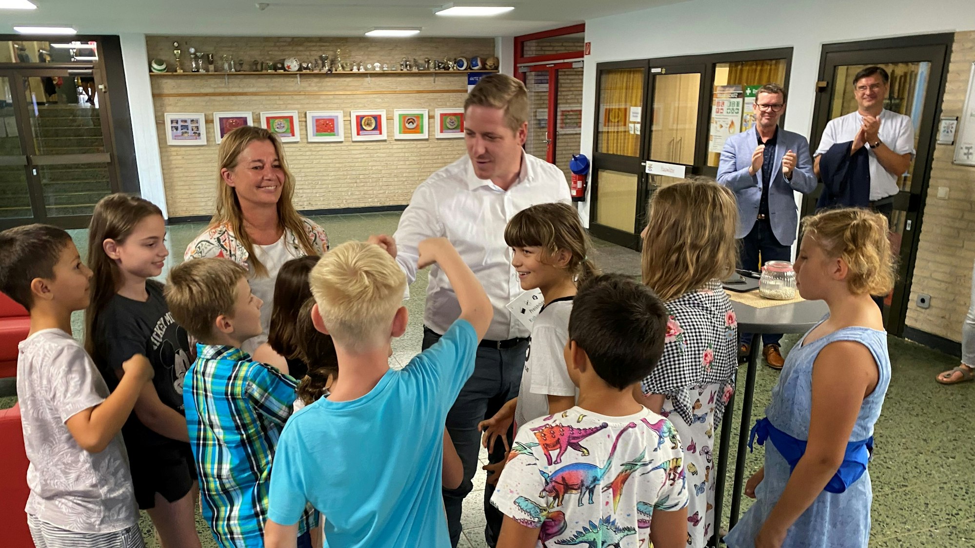 Inmitten vieler Schüler stehen Landrat Markus Ramers und die Künstlerin Alex Rix. Die Schüler klatschen mit dem Landrat ab.
