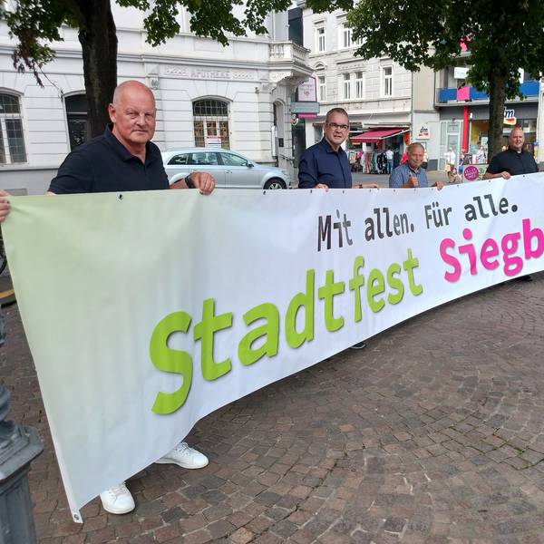 Fünf Männer halten ein Transparent mit einer Werbung für das Siegburger Stadtfest