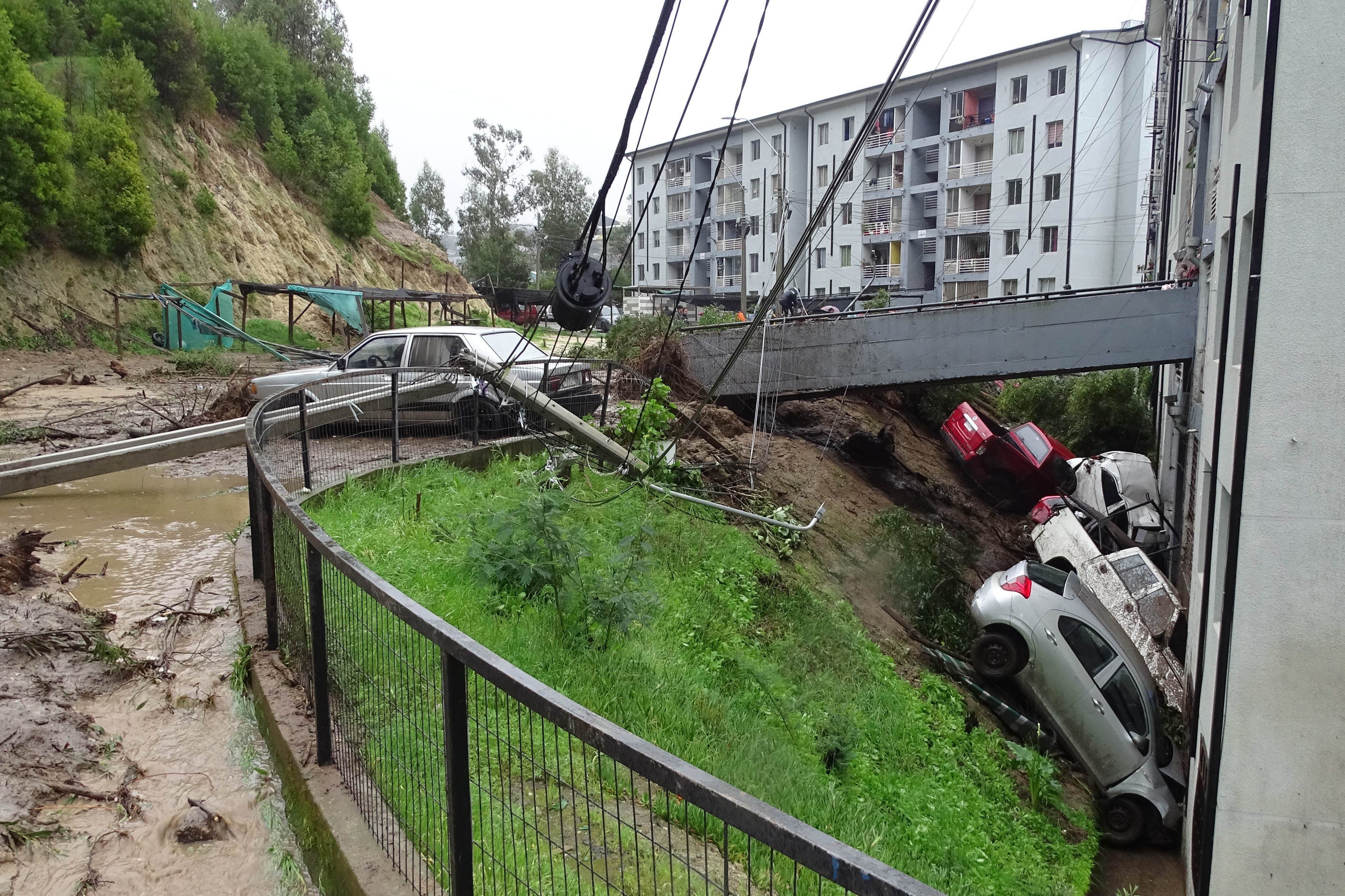 21.08.2023, Chile, Constitucion: Autos, die von einem durch starke Regenfälle verursachten Erdrutsch in Constitucion weggeschwemmt wurden, sind gegen ein Gebäude geprallt.