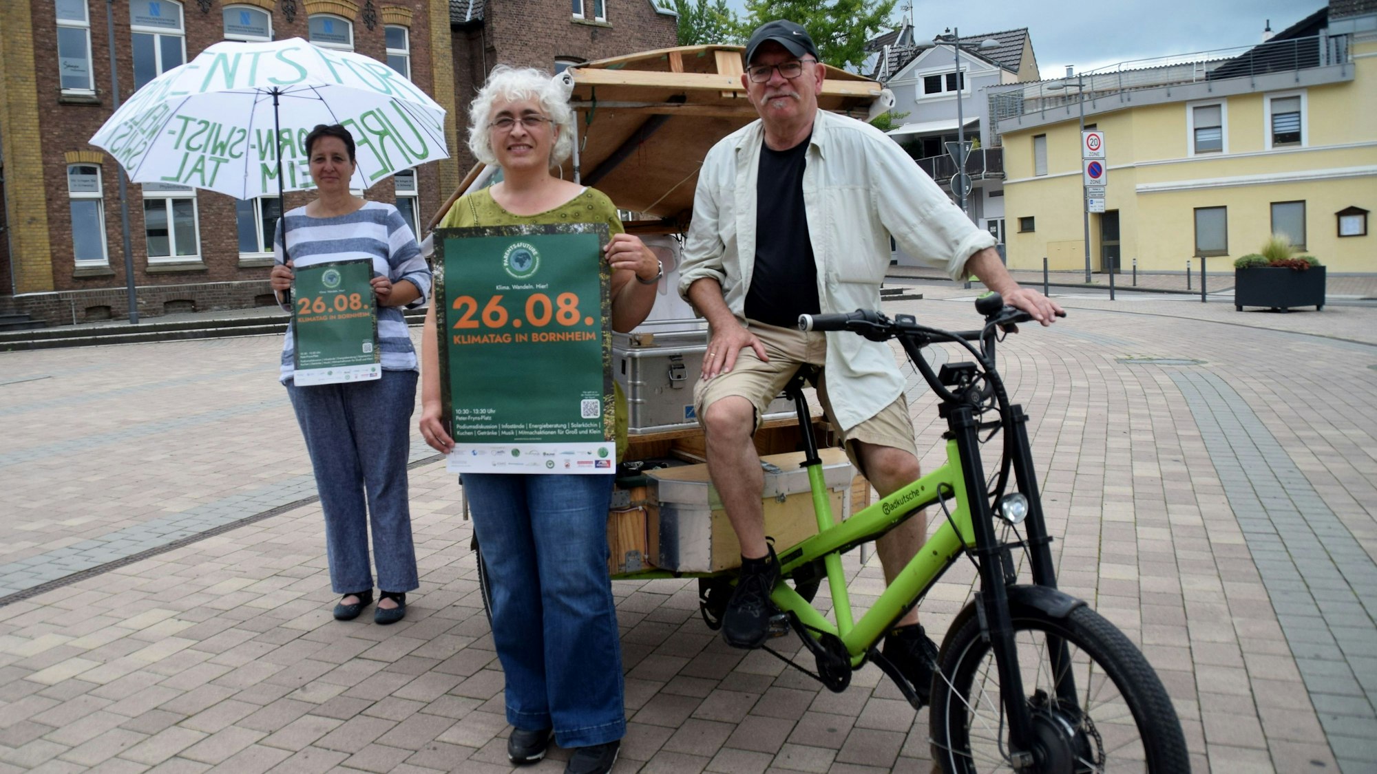 Astrid Costard, Barbara Lehmann-Detscher und Berthold Lehn (von links) von den Parents for Future Bornheim/Swisttal/Weilerswist werben für den Klimatag auf dem Peter-Fryns-Platz in Bornheim. Foto: Frank Engel-Strebel