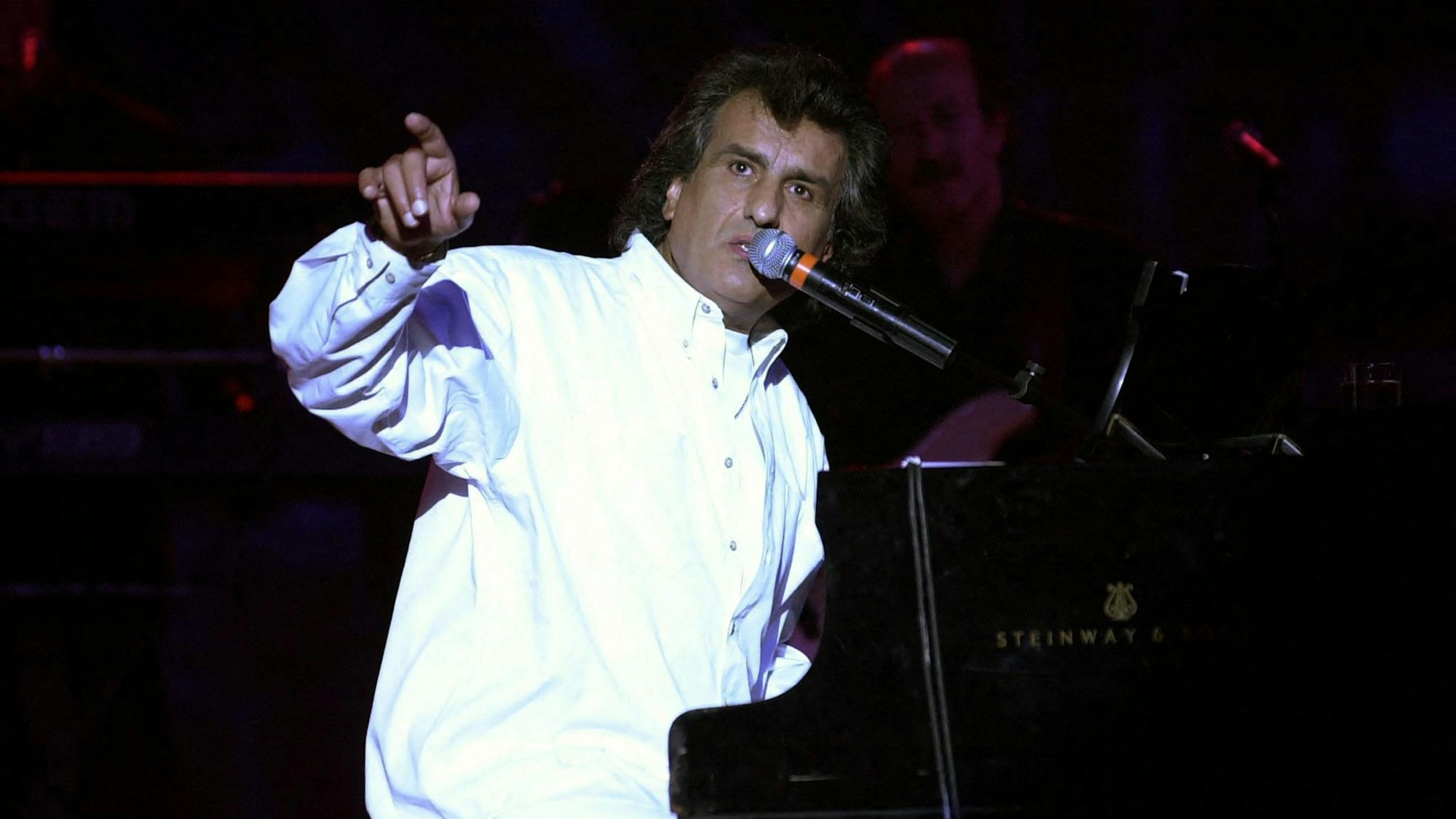 (FILES) Italian singer and composer Toto Cutugno performs late on July 26, 2002 at the Roman theater outside Tunis during the 38th international festival of Cartagena. Toto Cutugno, famous in Italy and abroad for his hit "Un Italiano vero" and his Eurovision victory in 1990 with "Insieme: 1992", died at the age of 80 on August 22, 2023 in Milan according to the Italian agency Ansa. (Photo by Fethi Belaid / AFP)