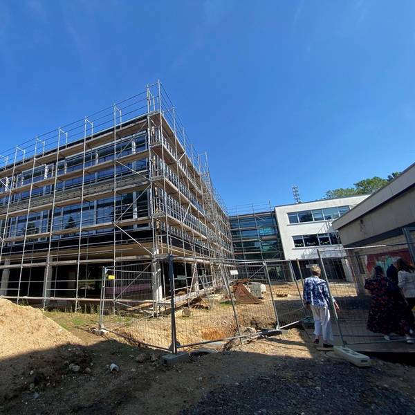 Das Bild zeigt den dreigeschossigen Neubau der Schule, der noch von einem Gerüst umgeben ist.