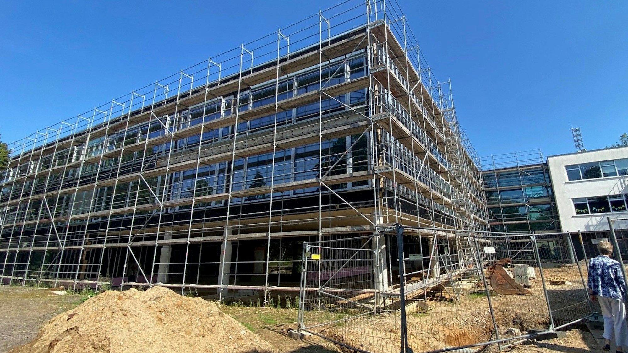 Das Bild zeigt den dreigeschossigen Neubau der Schule, der noch von einem Gerüst umgeben ist.