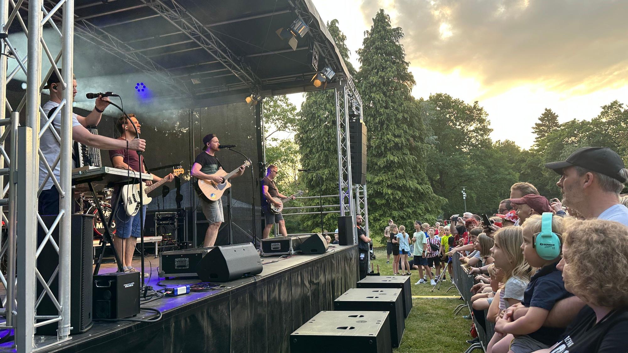 Eine Band steht auf der Bühne.