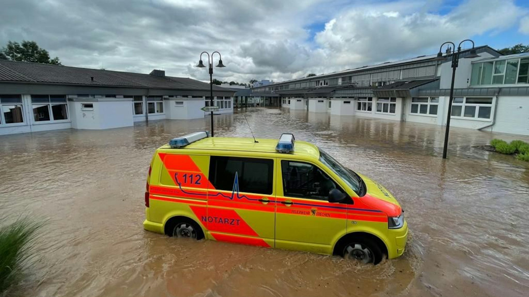 Ein Notarztwagen steht vor dem Marien-Hospital Erftstadt im Wasser.