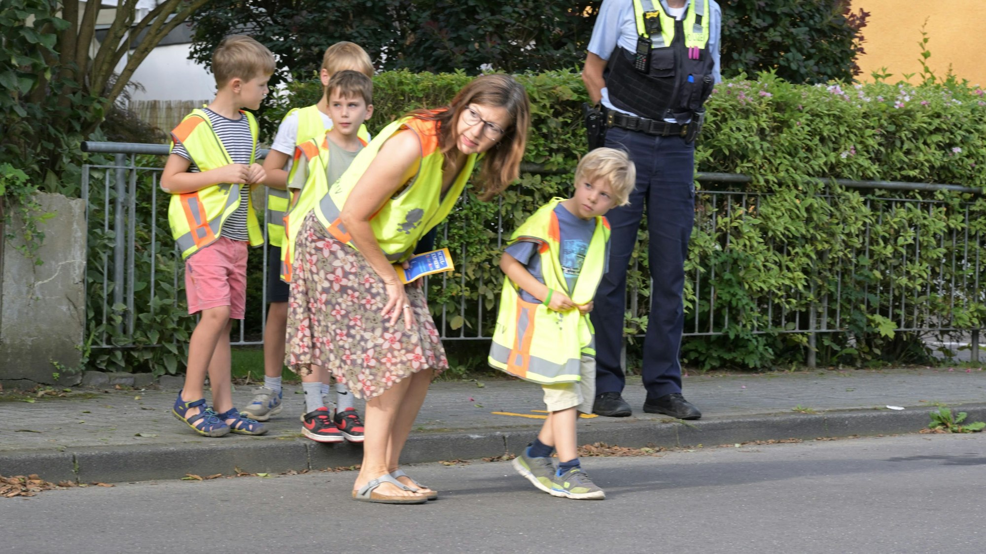 An der Grundschule in der Auen in Refrath üben Kinder unter Aufsicht die sichere Überquerung von Straßen.