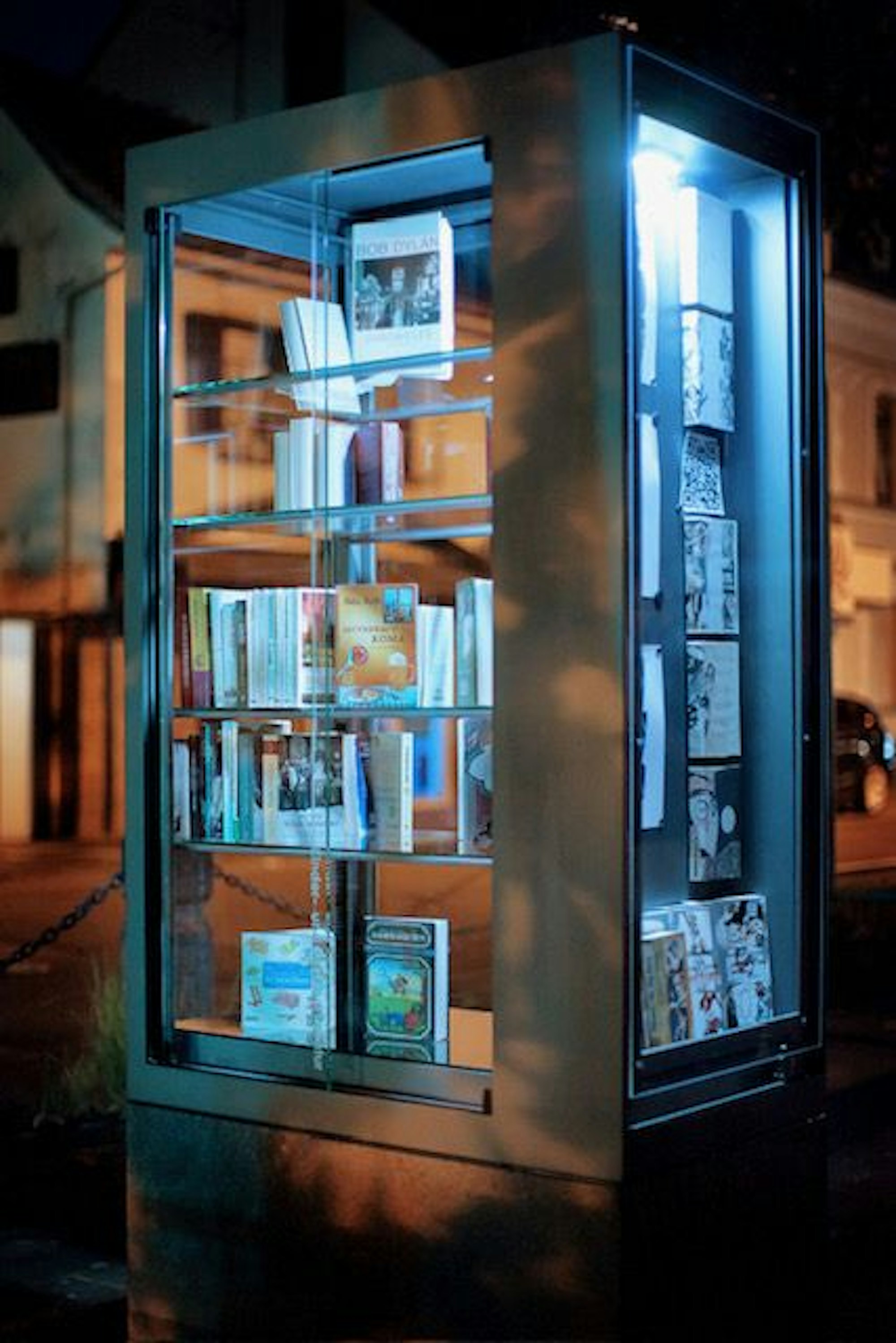 Eine beleuchtete Vitrine mit darin ausgestellten Büchern ist zu sehen.