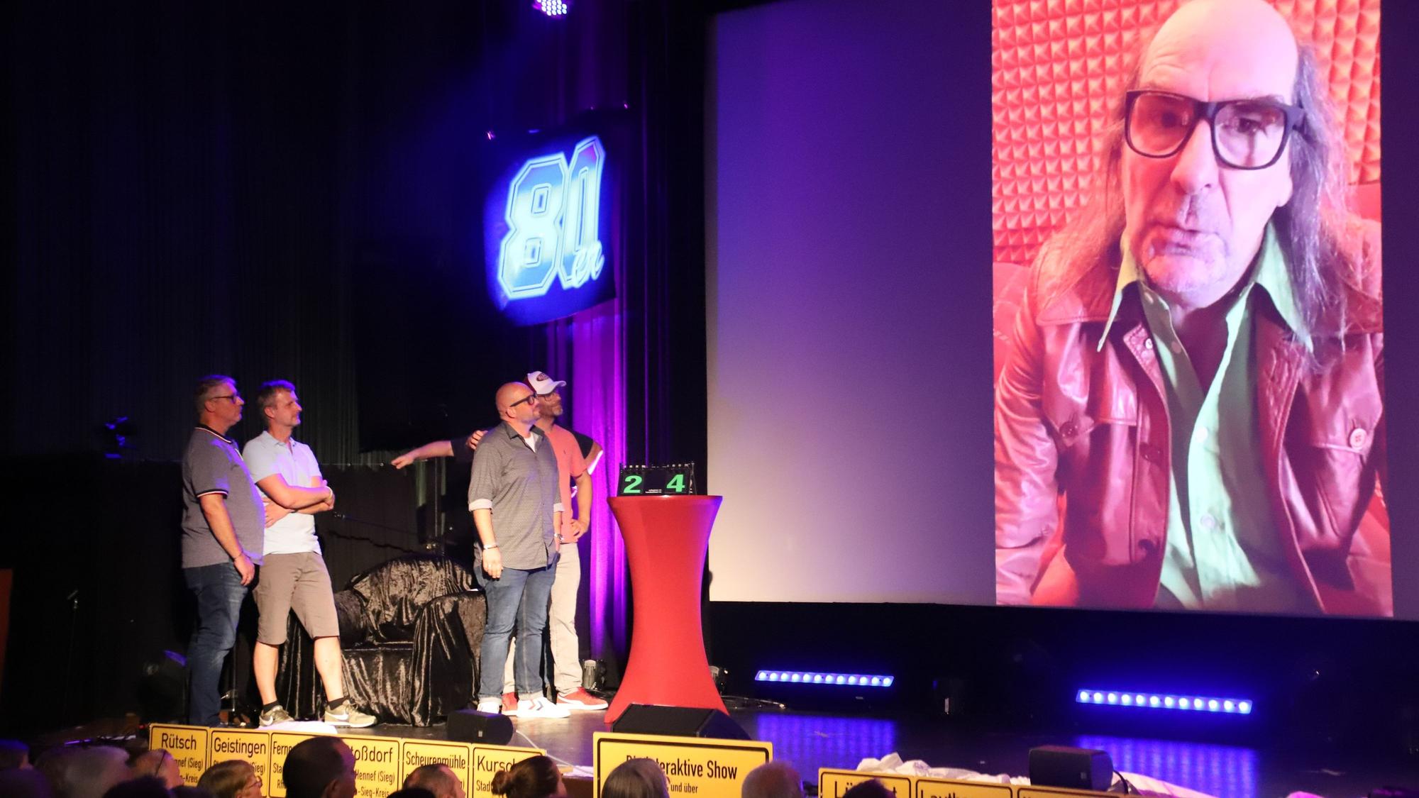 Uli Birkmann und Stévéé Ornowski nahmen die Gäste im Kurtheater mit auf eine Zeitreise in das Hennef der 80er- und 90er-Jahre. In einem Kandidatenspiel wird sogar Guildo Horn eingeblendet.