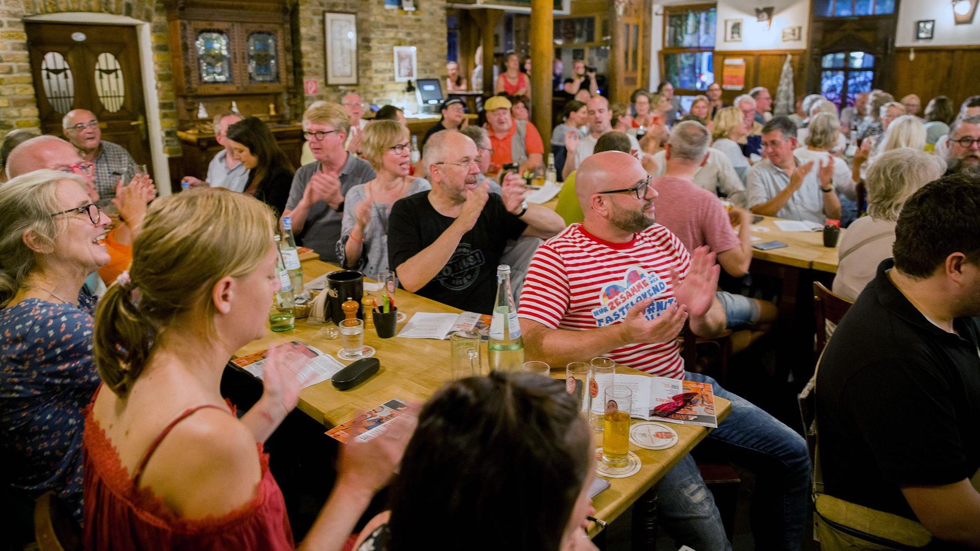 Zuschauerinnen und Zuschauer klatschen in die Hände.