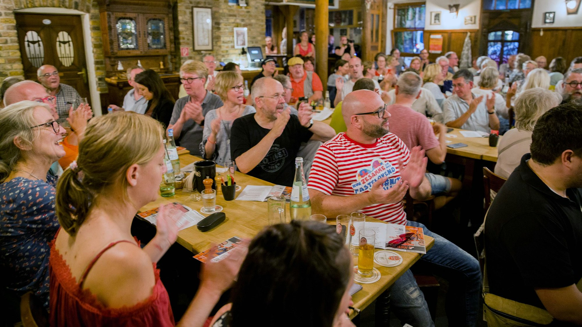 Zuschauerinnen und Zuschauer klatschen in die Hände.